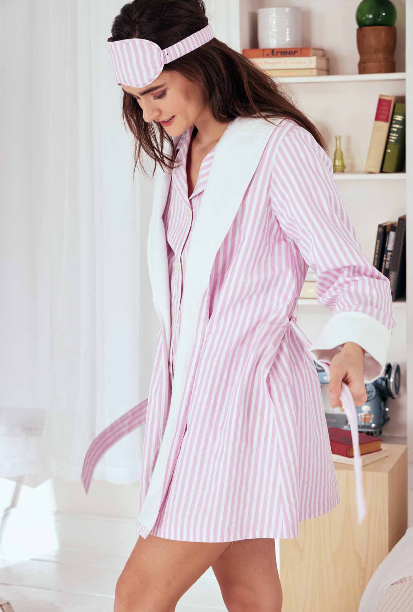 A lady wearing a pink and white stripes robe.