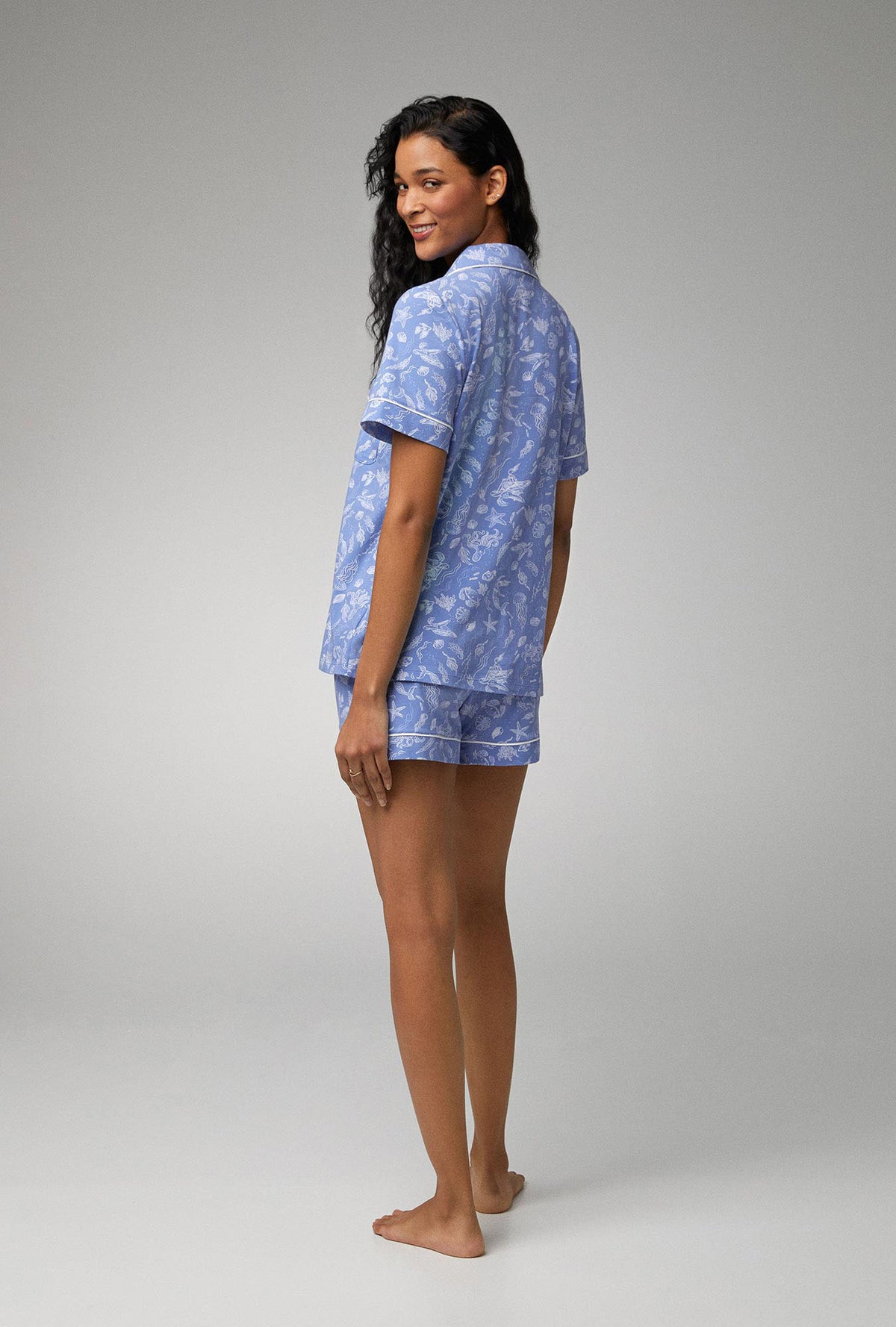 A lady wearing blue short sleeve classic shorty stretch jersey pj set with high tide print.