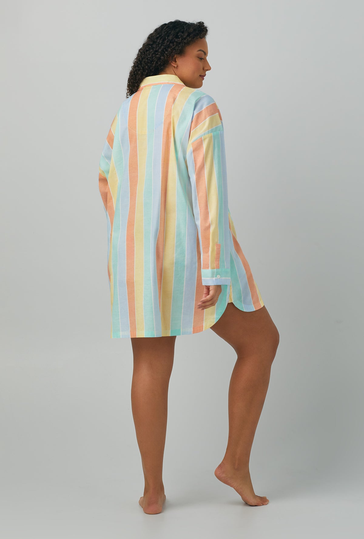A lady wearing plus size multi color Woven Cotton Poplin Boyfriend Shirt with Sunset Stripe print