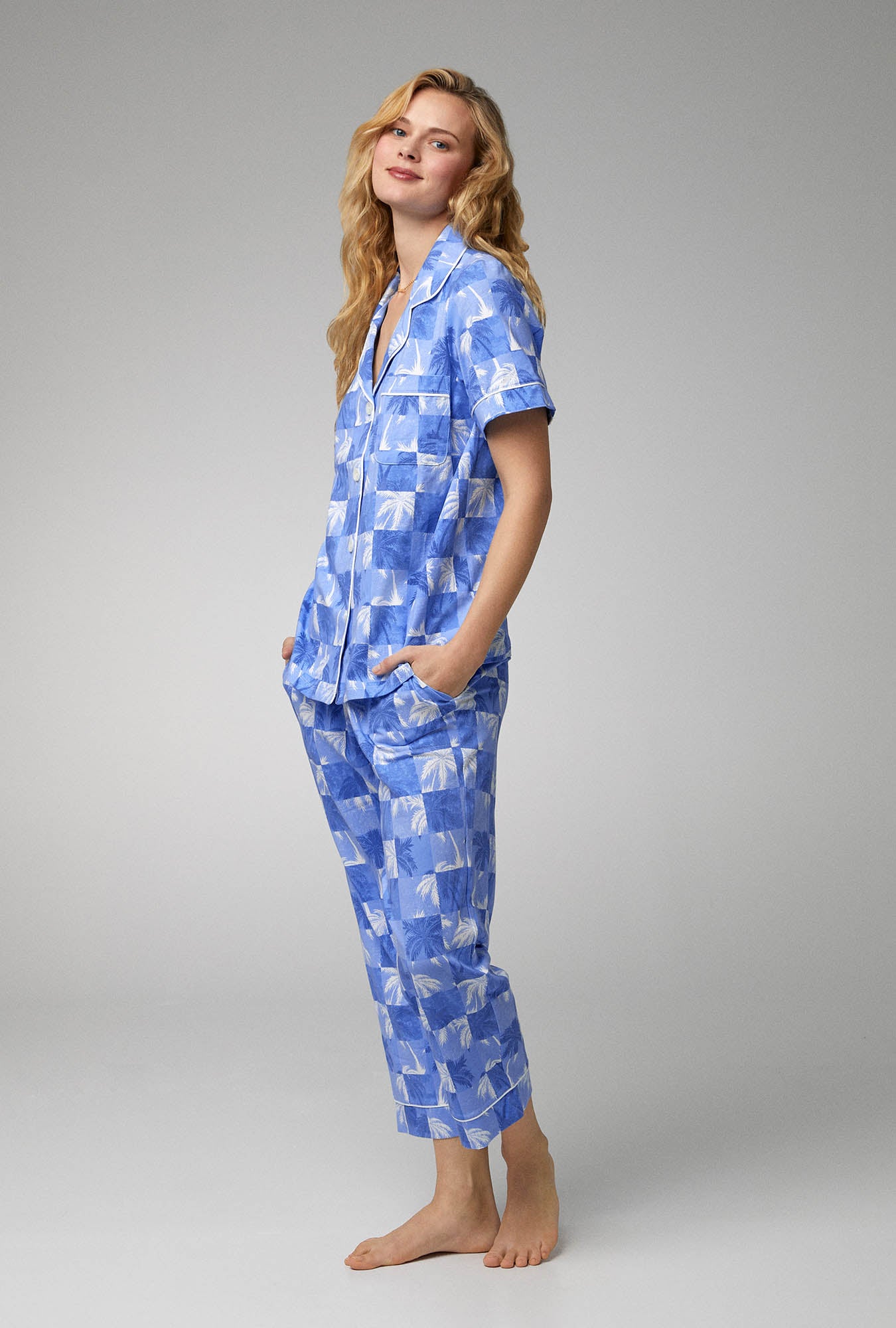 A lady wearing blue short sleeve classic stretch jersey cropped pj set with cool palms print.