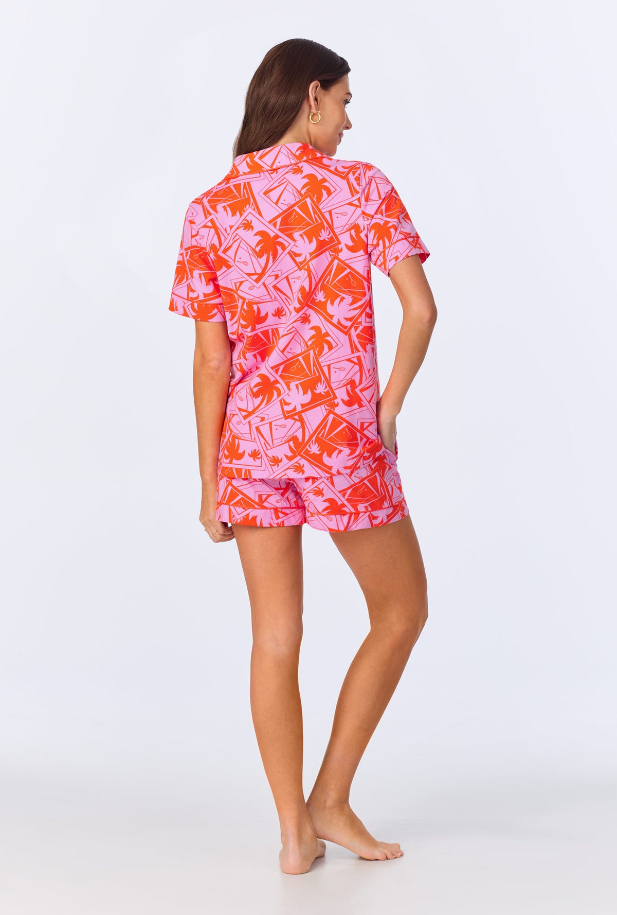 A lady wearing BedHead x Trina Turk Pink Tennis Court Sleeve Classic Shorty Stretch Jersey PJ Set