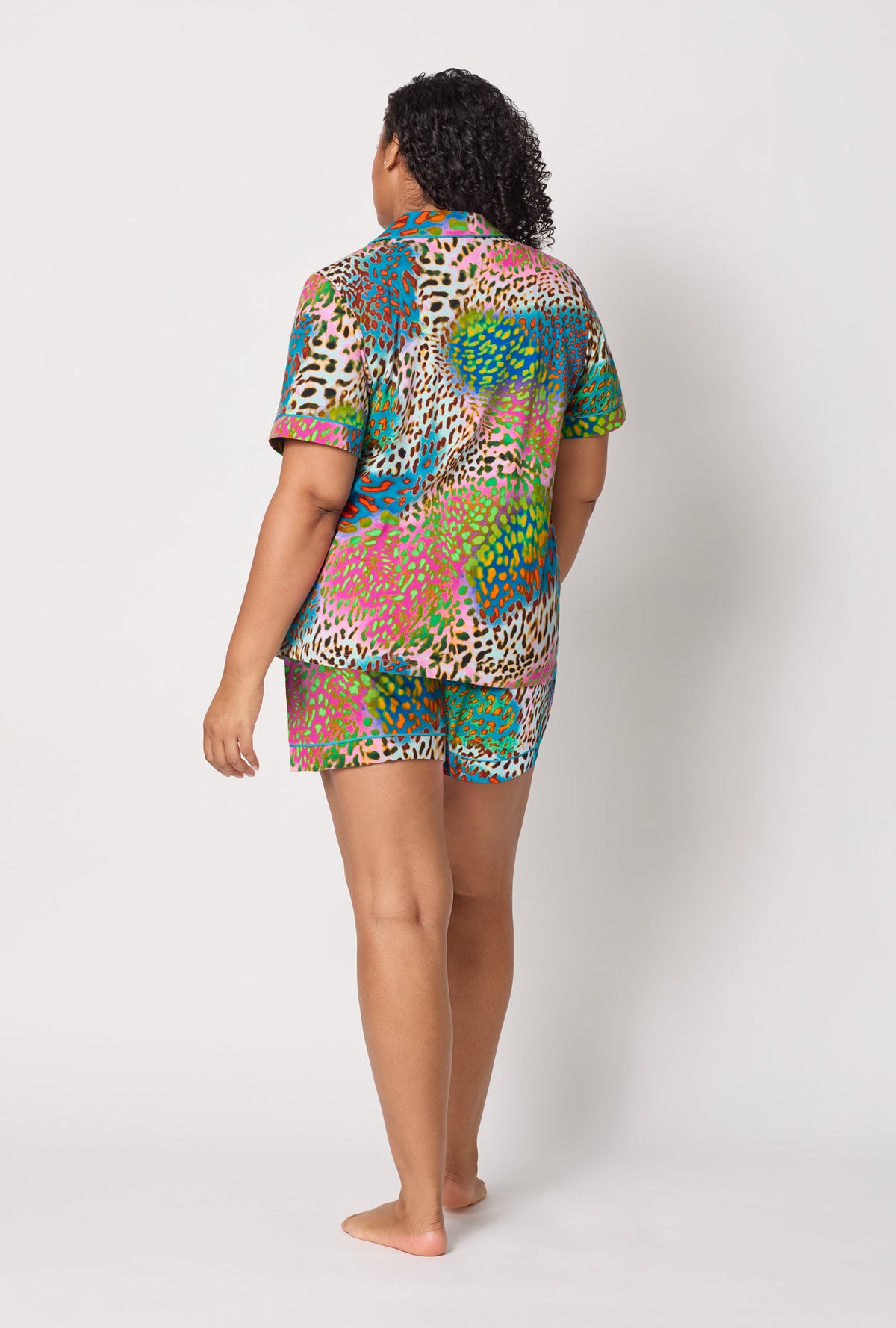 A lady wearing plus size BedHead x Trina Turk Spray Leopard Short Sleeve Classic Shorty Stretch Jersey Pj Set