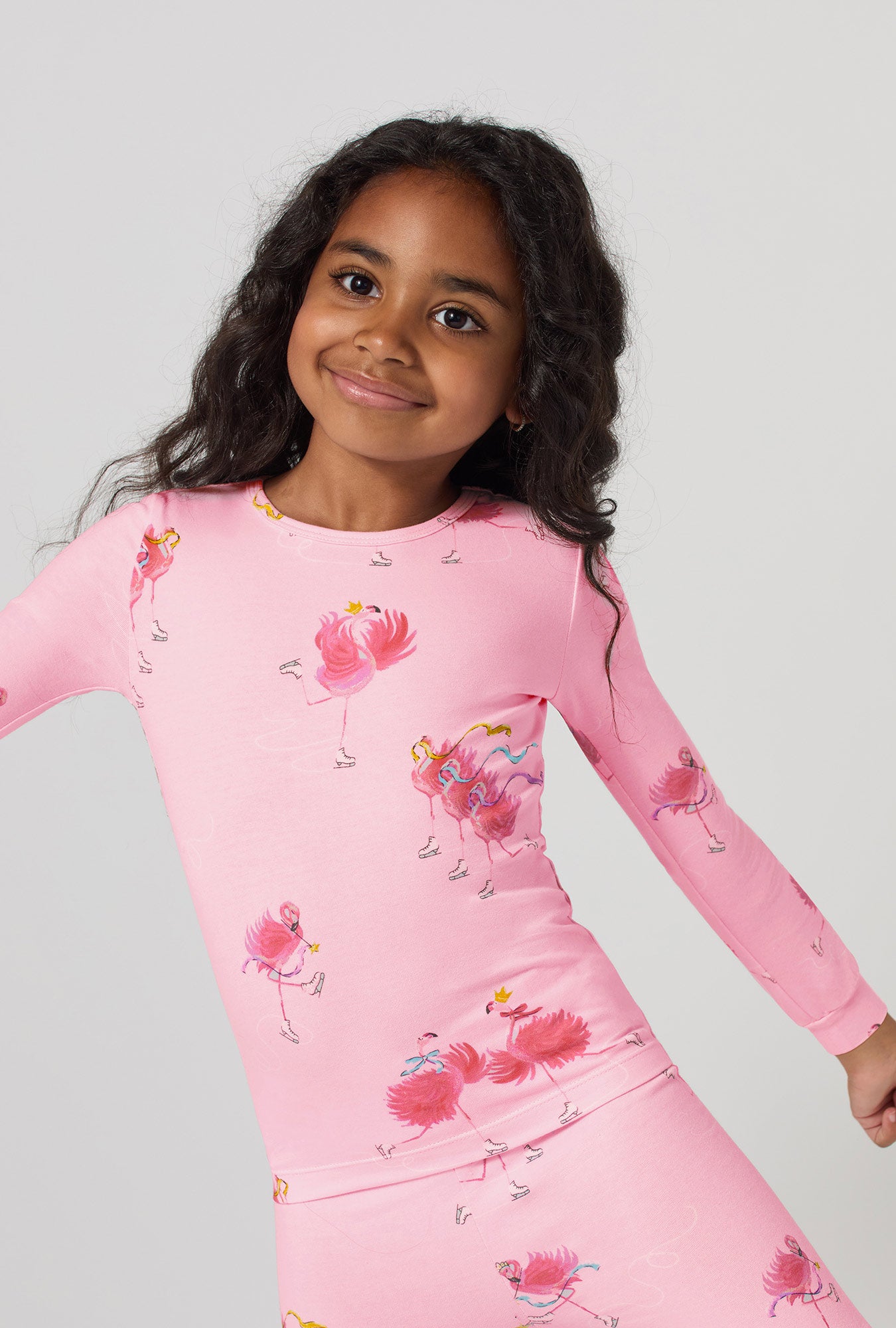 A girl wearing Flamingos On Ice Long Sleeve Stretch Jersey Kids Pj Set