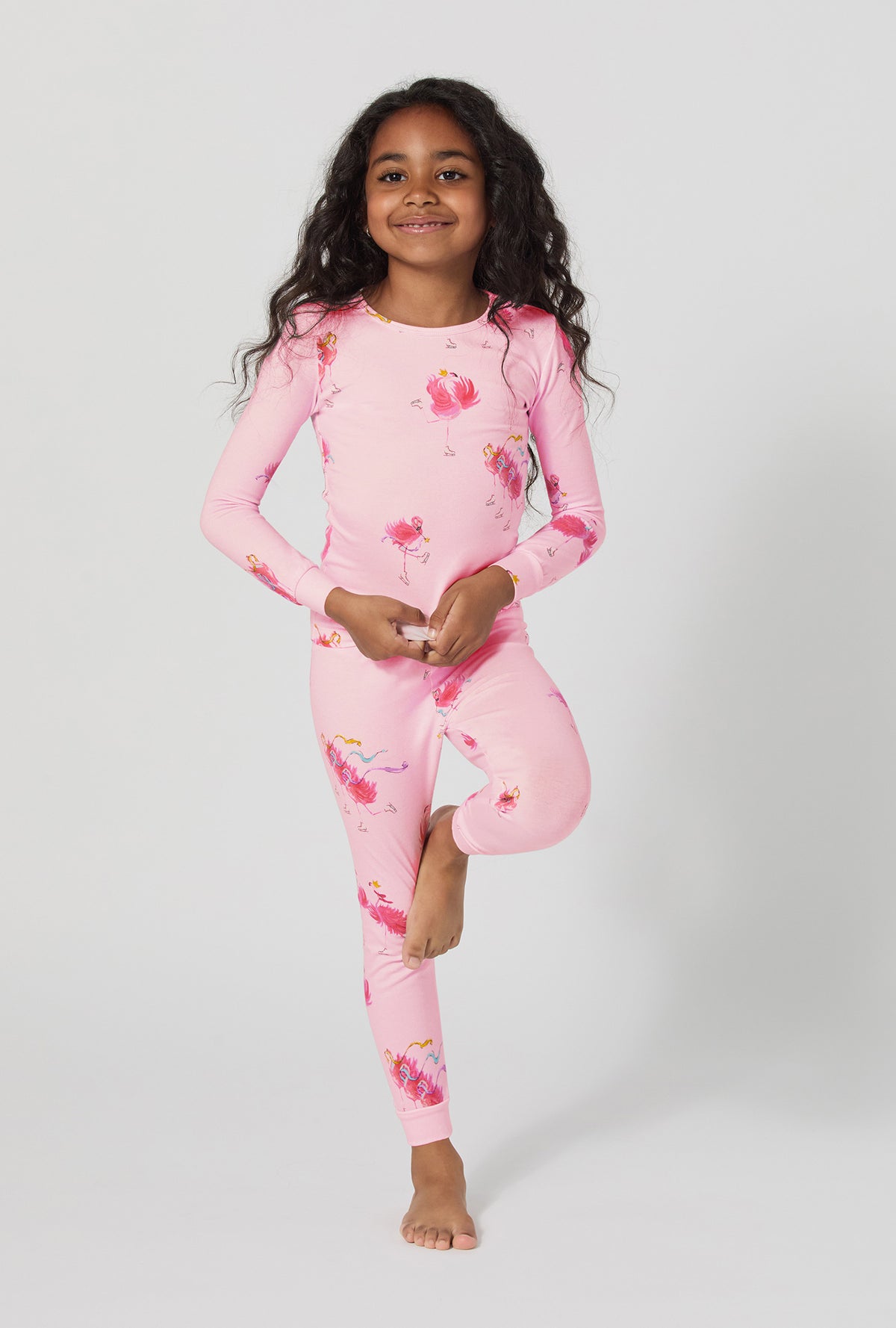 A girl wearing Flamingos On Ice Long Sleeve Stretch Jersey Kids Pj Set