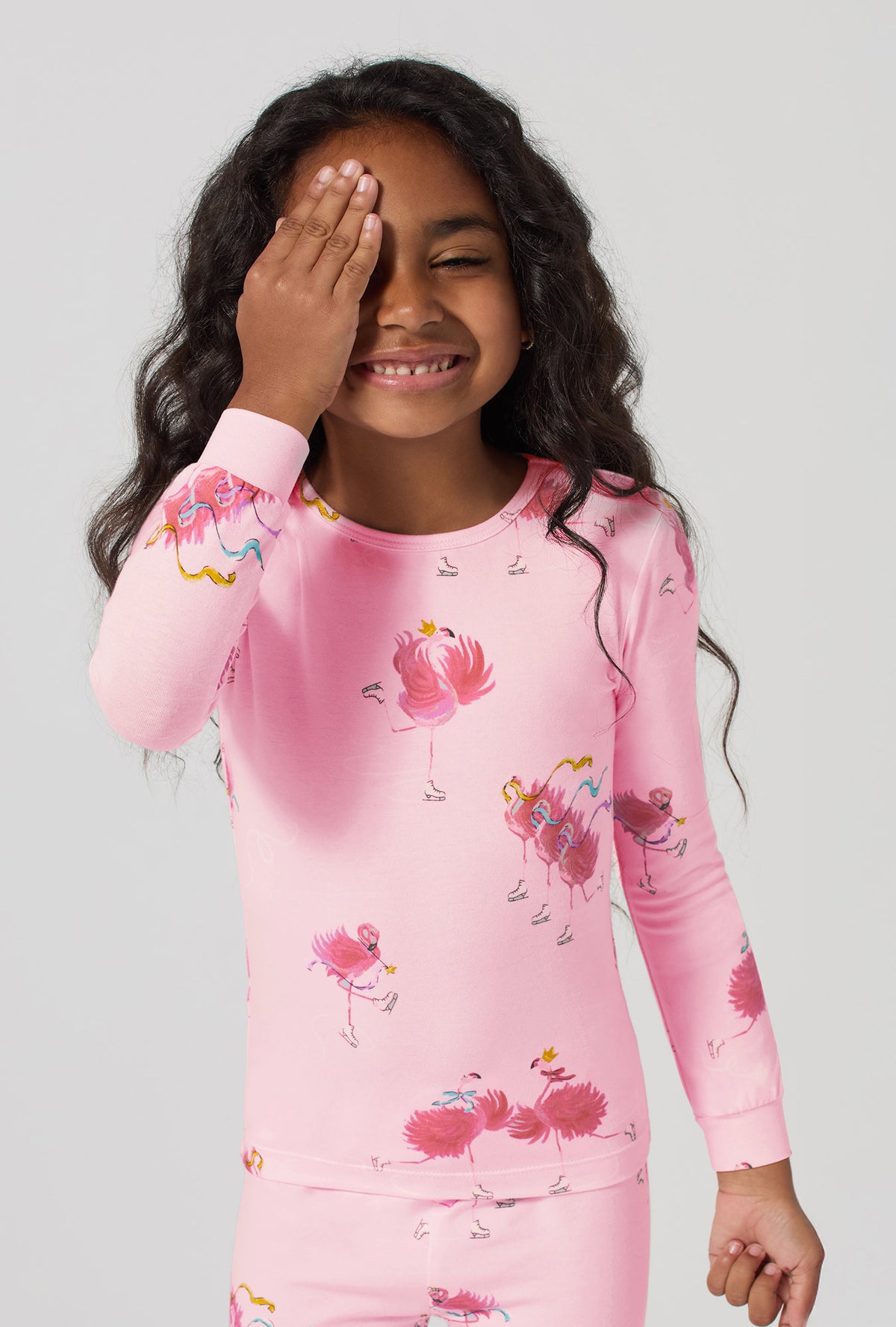 A girl wearing Flamingos On Ice Long Sleeve Stretch Jersey Kids Pj Set