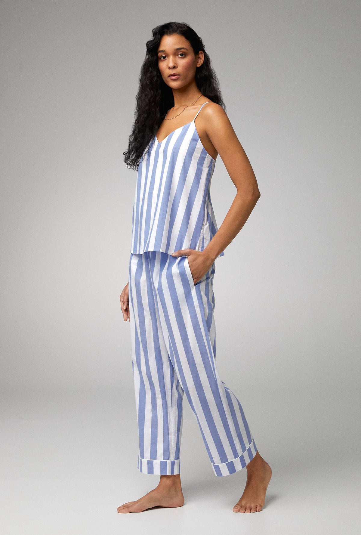 A lady wearing blue sleeveless v-neck tank woven cotton poplin cropped pj set with bengal stripe print.