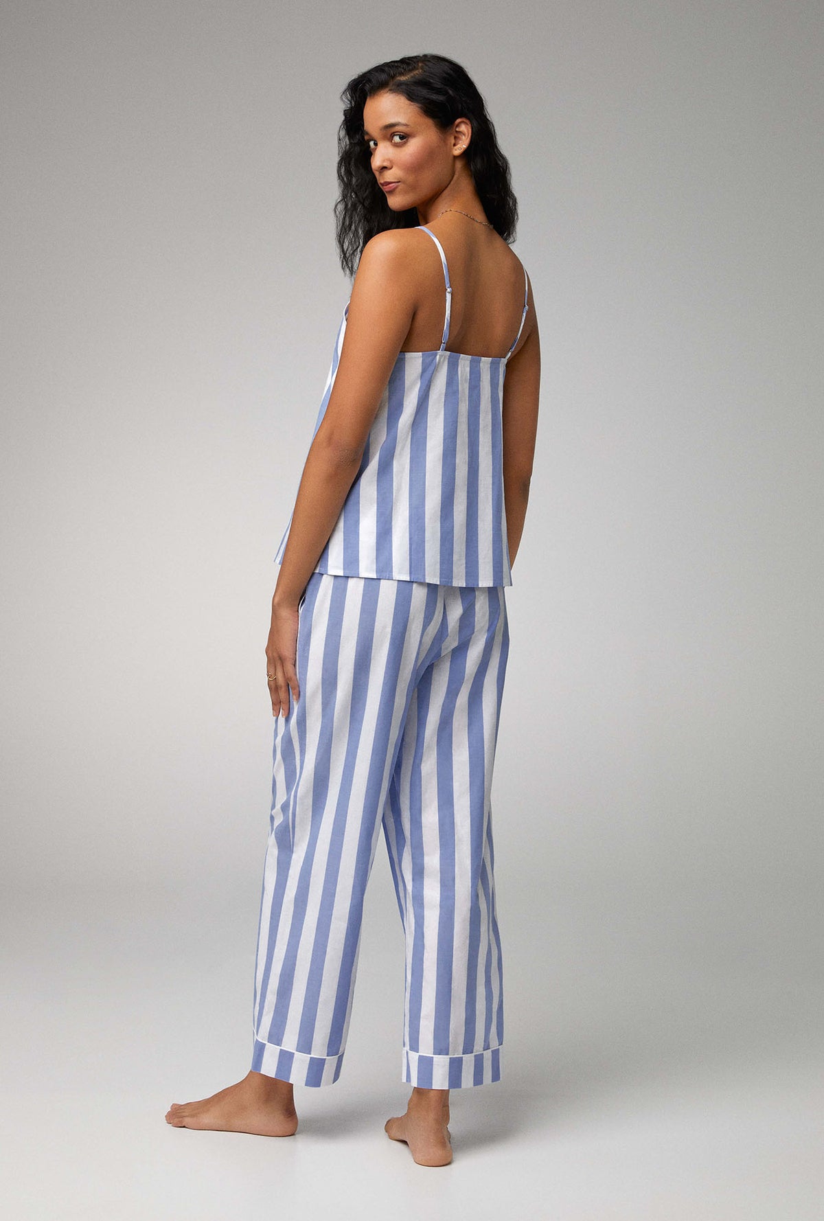 A lady wearing blue sleeveless v-neck tank woven cotton poplin cropped pj set with bengal stripe print.