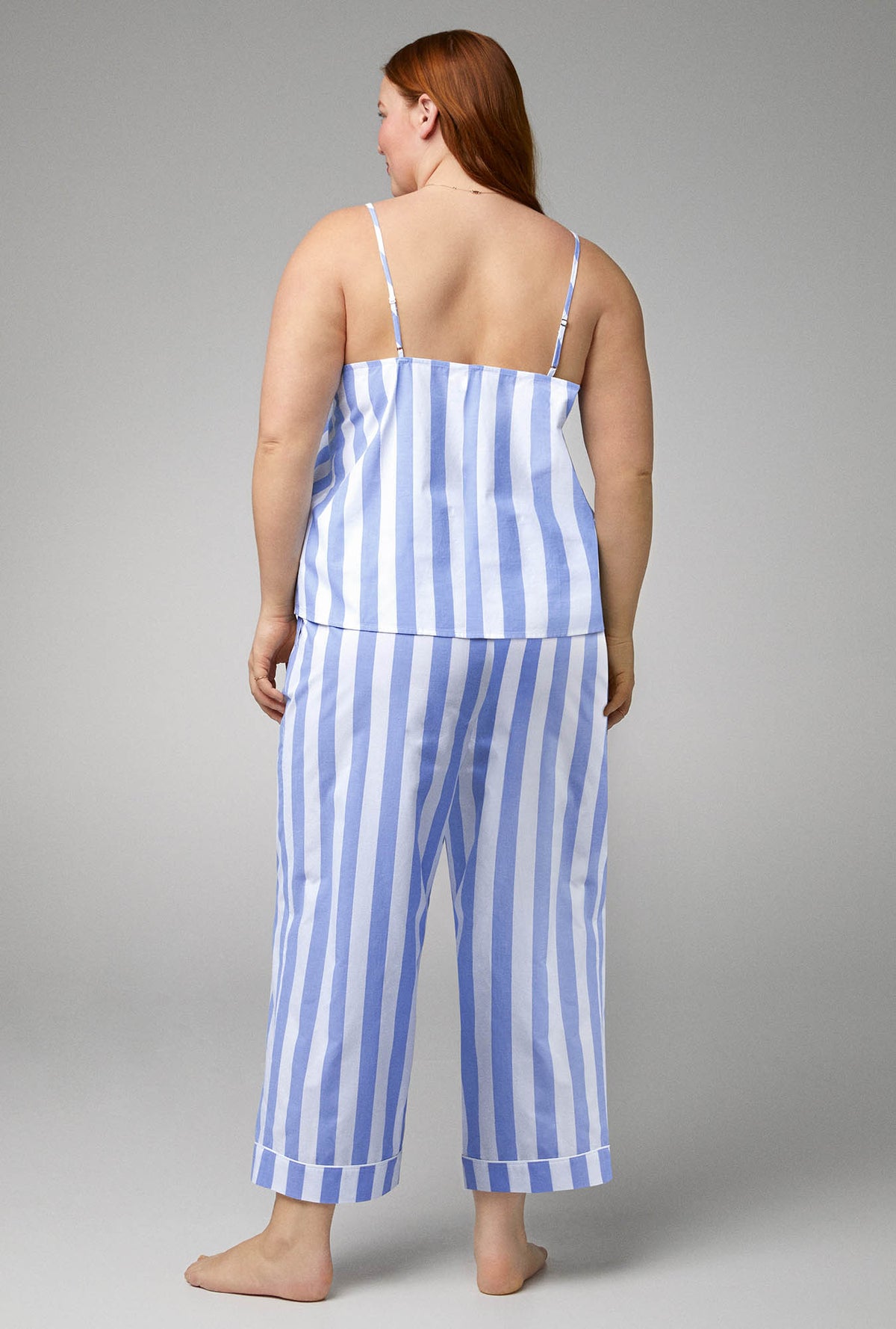 A lady wearing blue sleeveless v-neck tank woven cotton poplin cropped plus size pj set with bengal stripe print.