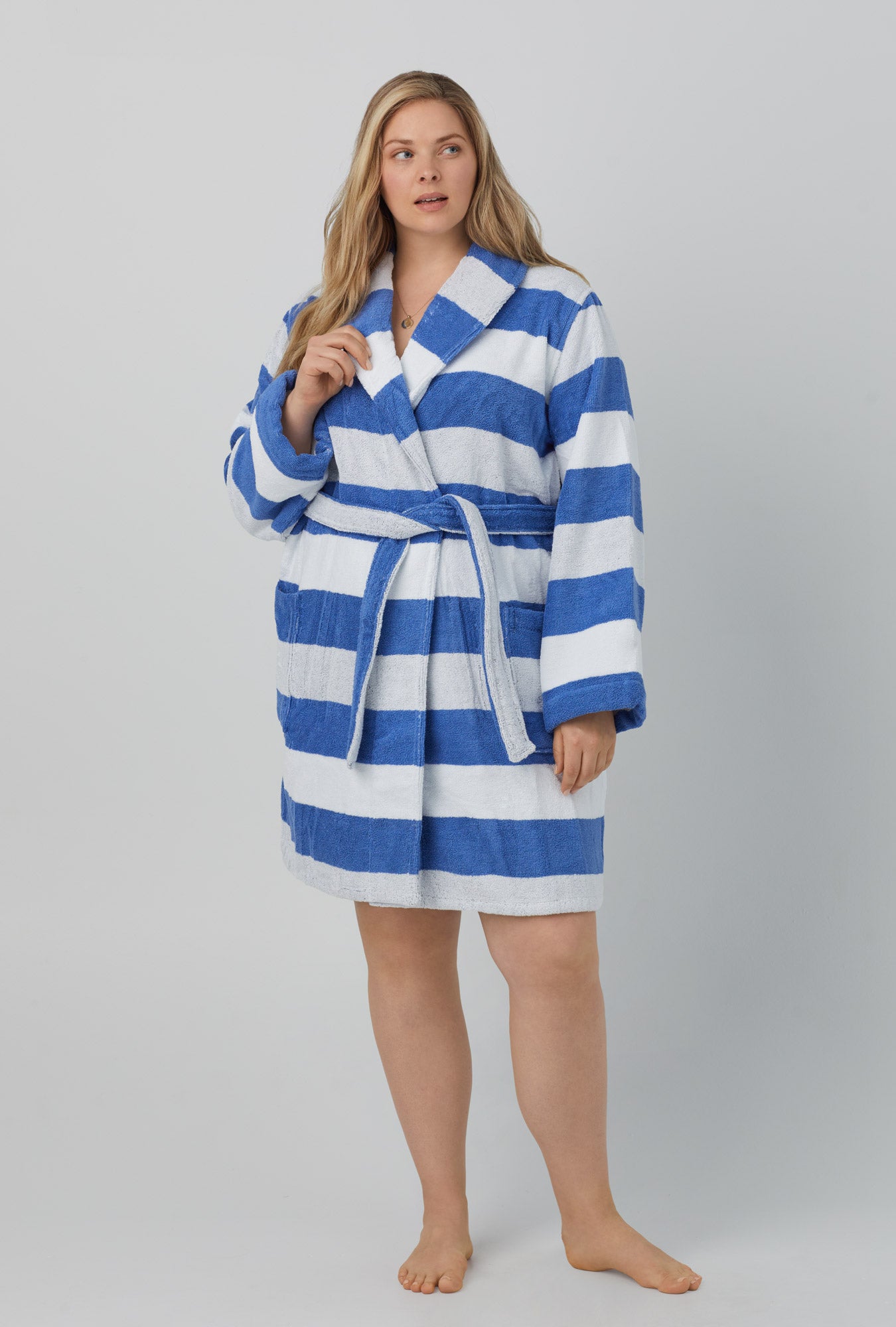 A lady wearing white and blue unisex woven cotton loop turkish terrry jacquard short robe with seaside stripe print.