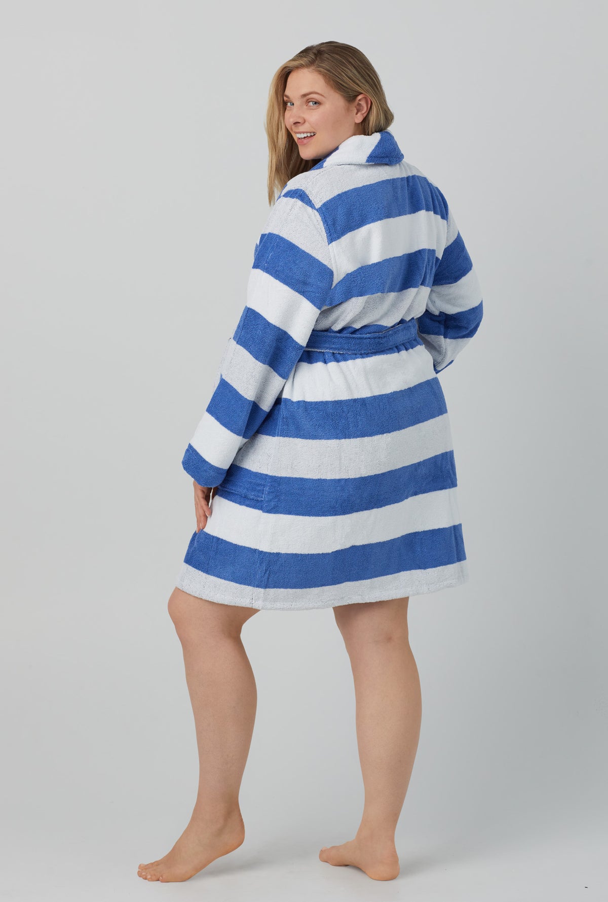 A lady wearing white and blue unisex woven cotton loop turkish terrry jacquard short robe with seaside stripe print.