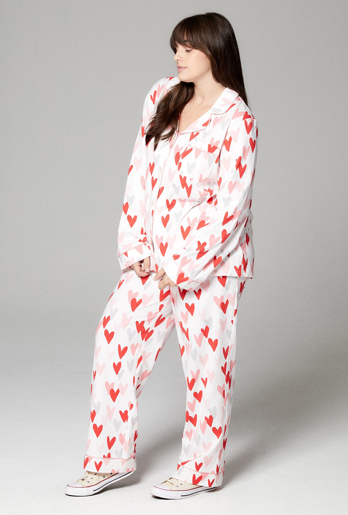 A lady wearing white long sleeve classic stretch jersey pj set with pink and red hearts print