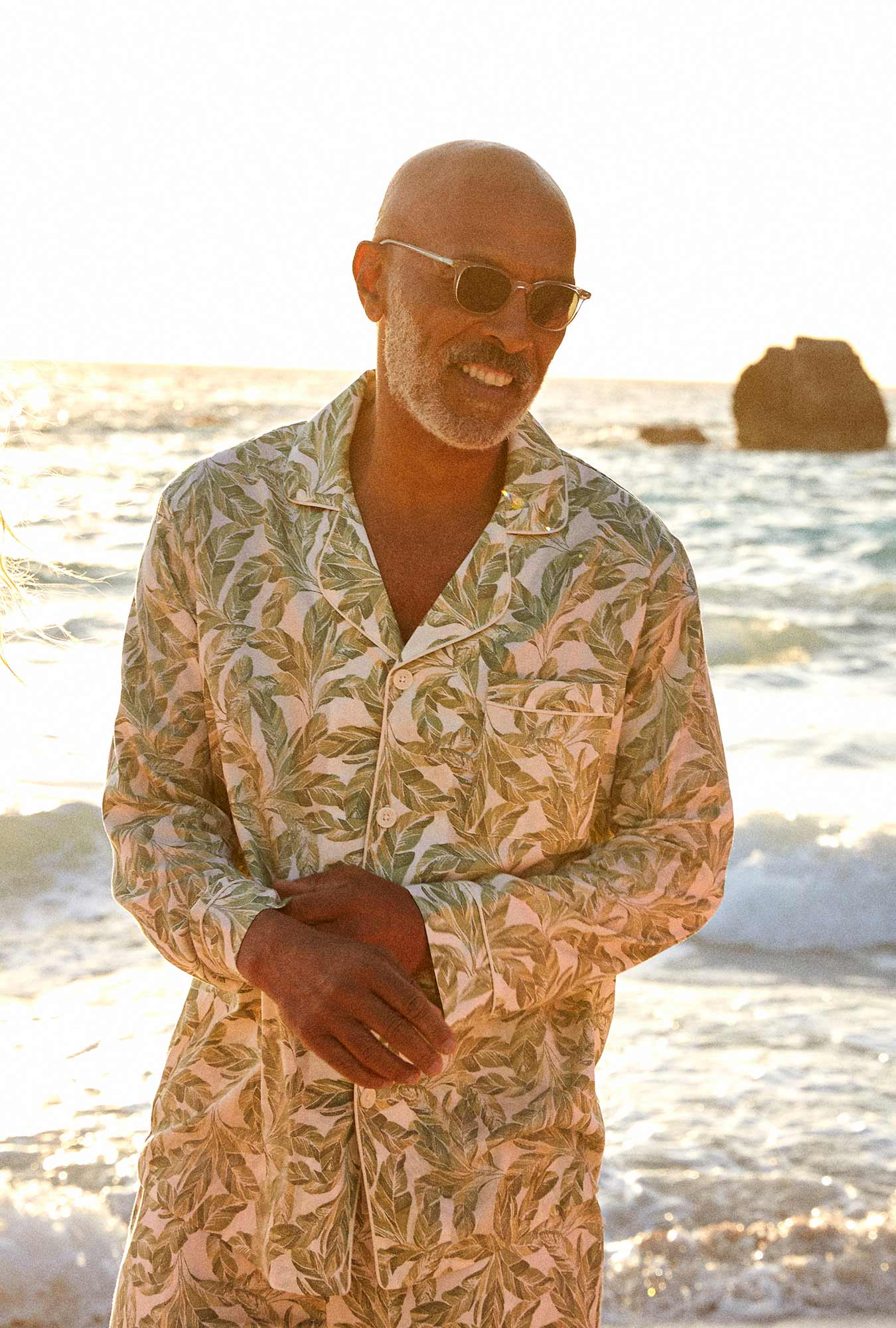 A man wearing a green long sleeve pj set with palm leave pattern.