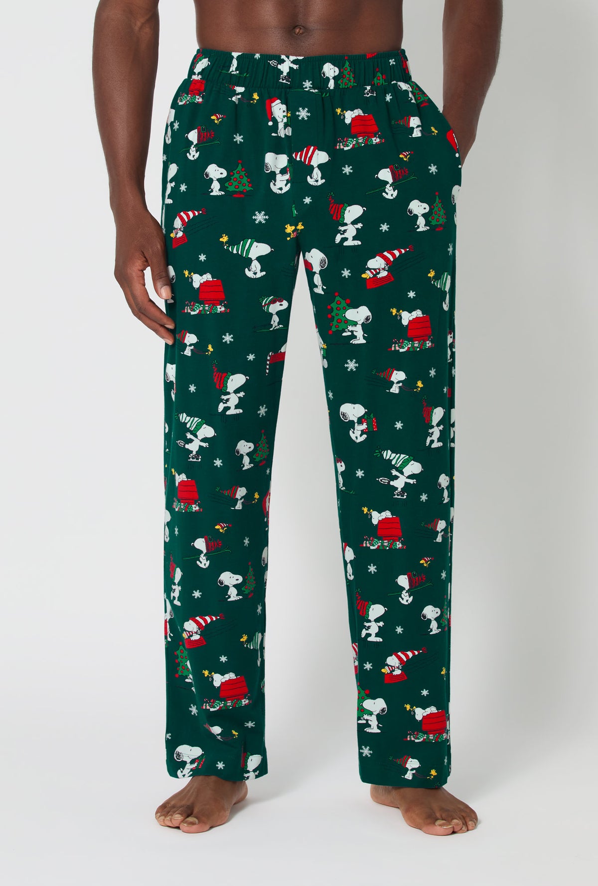 A man wearing ®Snoopy&#39;s Holiday Fun Men&#39;s Stretch Jersey Pj Pant