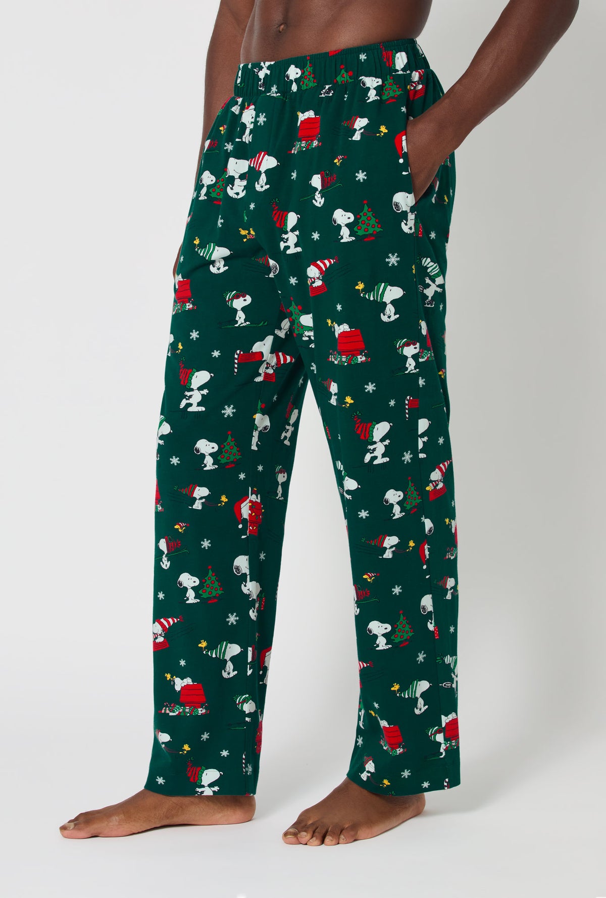 A man wearing ®Snoopy&#39;s Holiday Fun Men&#39;s Stretch Jersey Pj Pant