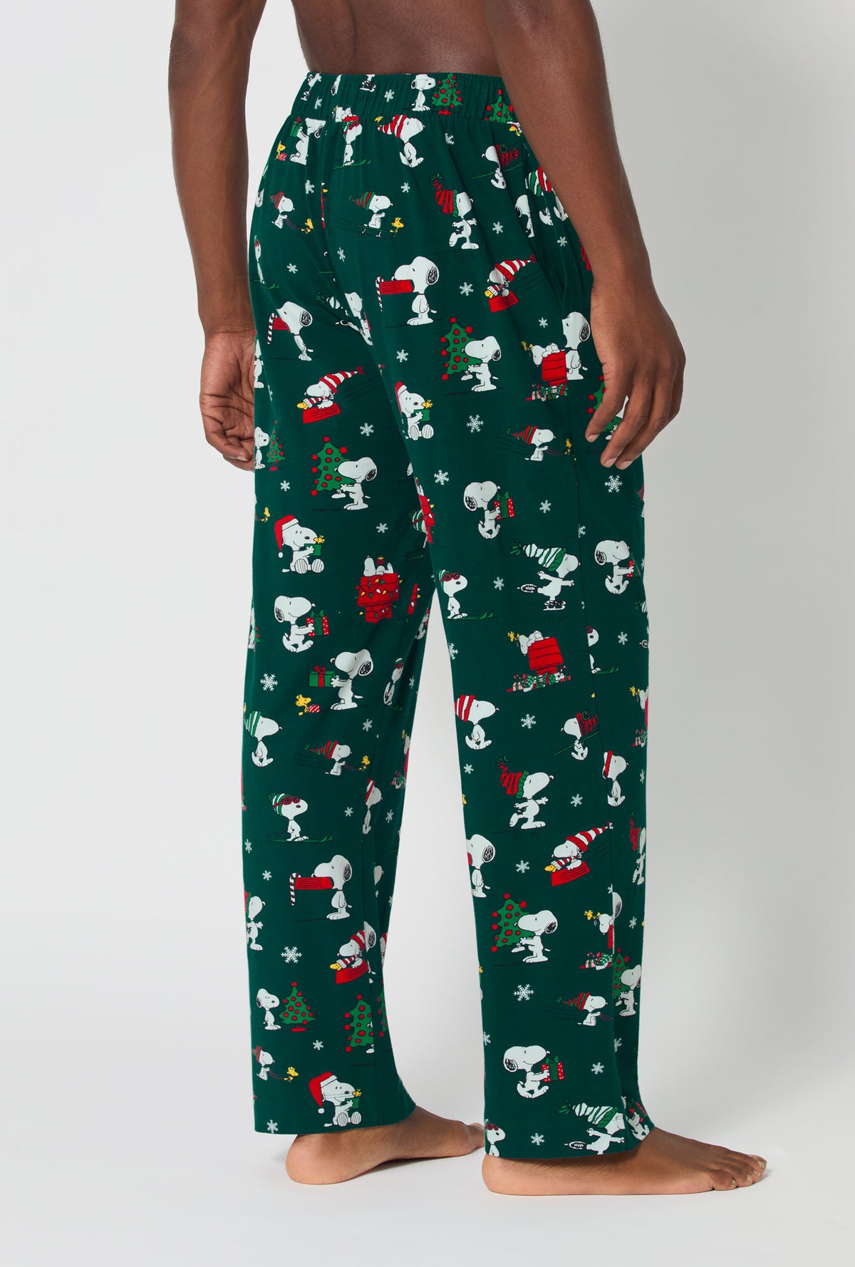 A man wearing ®Snoopy&#39;s Holiday Fun Men&#39;s Stretch Jersey Pj Pant