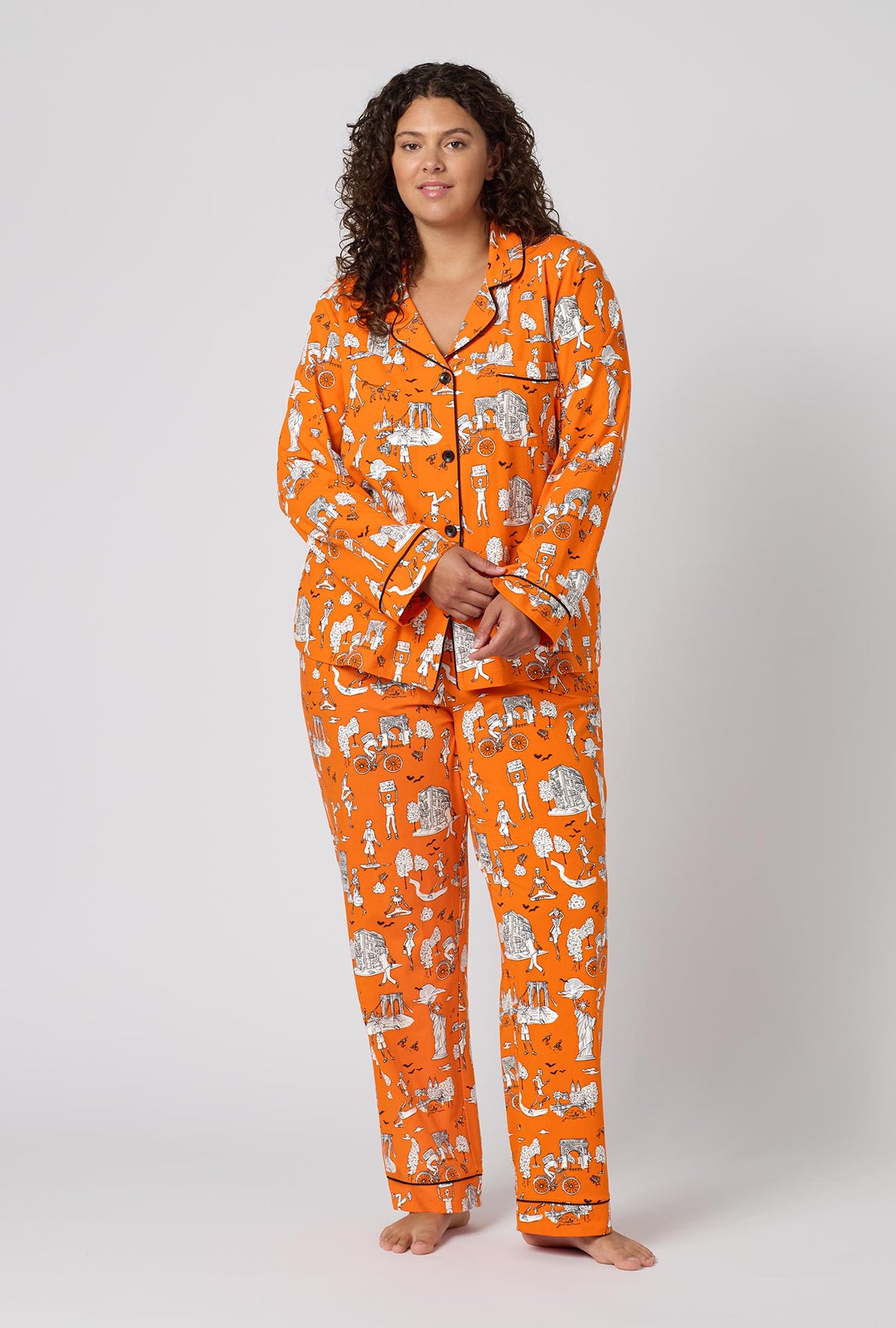A Lady Wearing Plus Size Orange Spooky In The City Long Sleeve Classic Stretch Jersey Pj Set