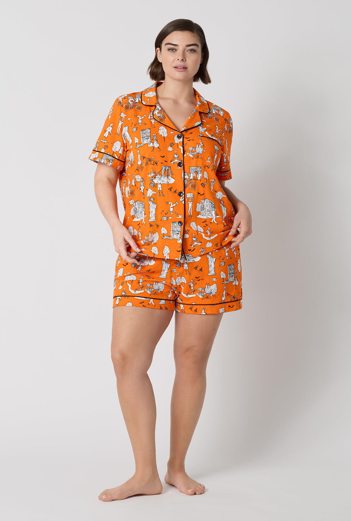 A Lady Wearing Plus Size Orange Spooky In The City Short Sleeve Classic Shorty Stretch Jersey Pj Set