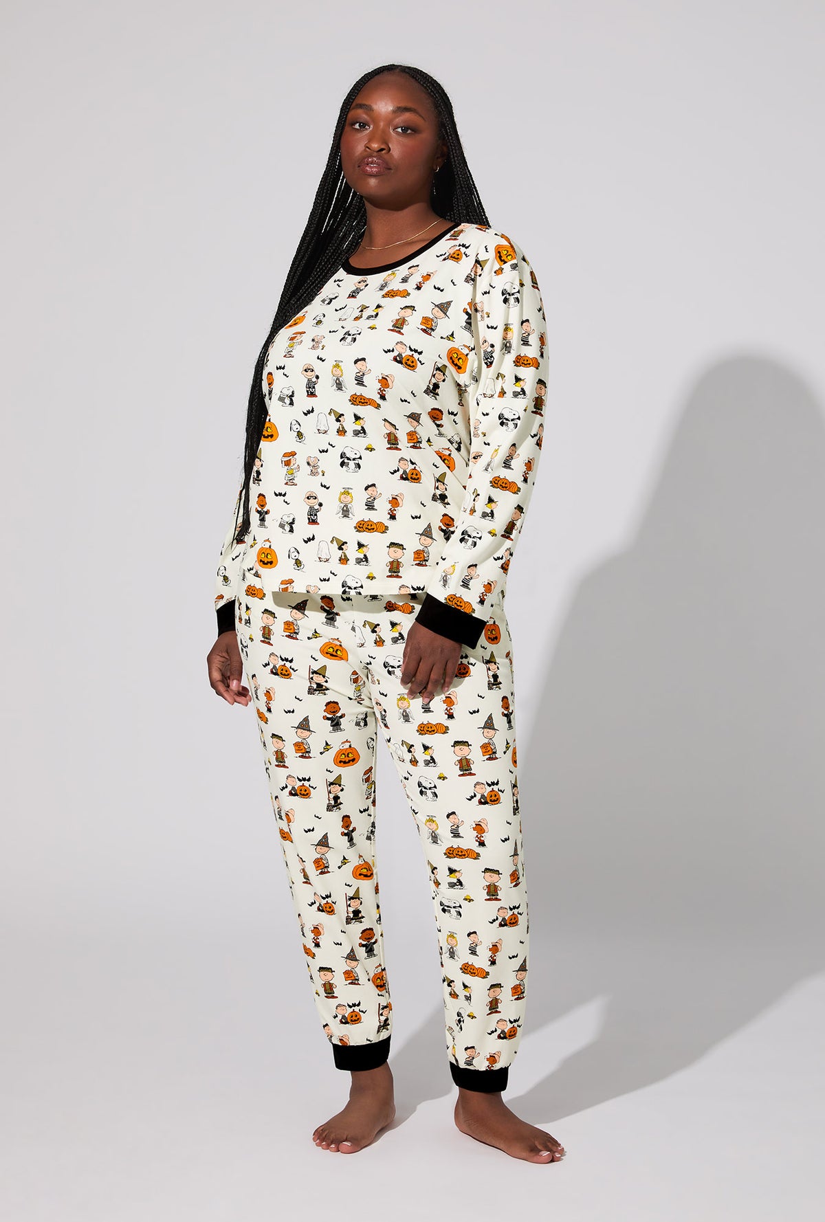 A lady wearing Peanuts® Snoopy&#39;s Halloween Long Sleeve Pullover Crew and Jogger Stretch Jersey PJ Set