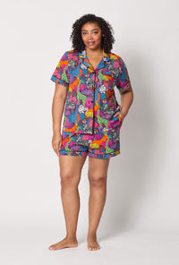A lady wearing plus size BedHead x Trina Turk Jungle Short Sleeve Classic Shorty Stretch Jersey Pj Set