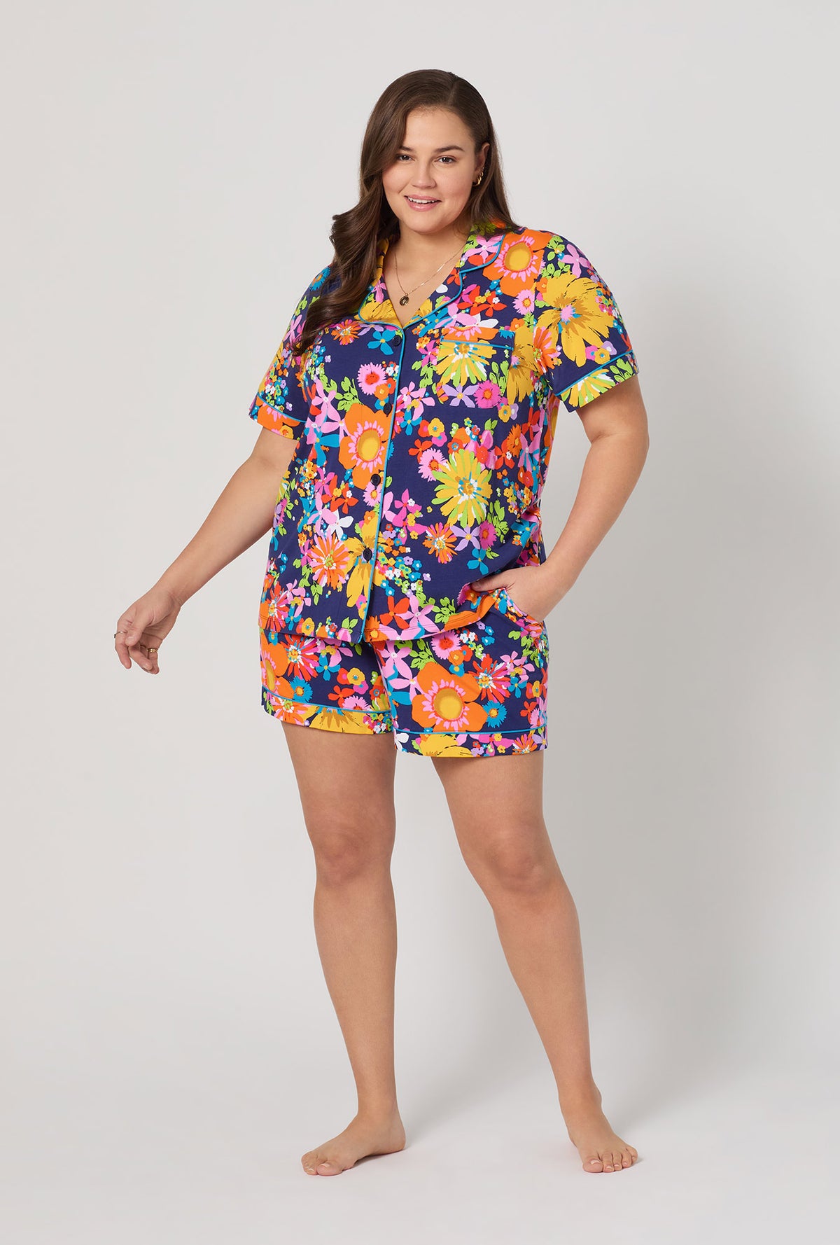 A lady wearing plus size BedHead x Trina Turk Bay Street Bloom Short Sleeve Classic Shorty Stretch Jersey Pj Set