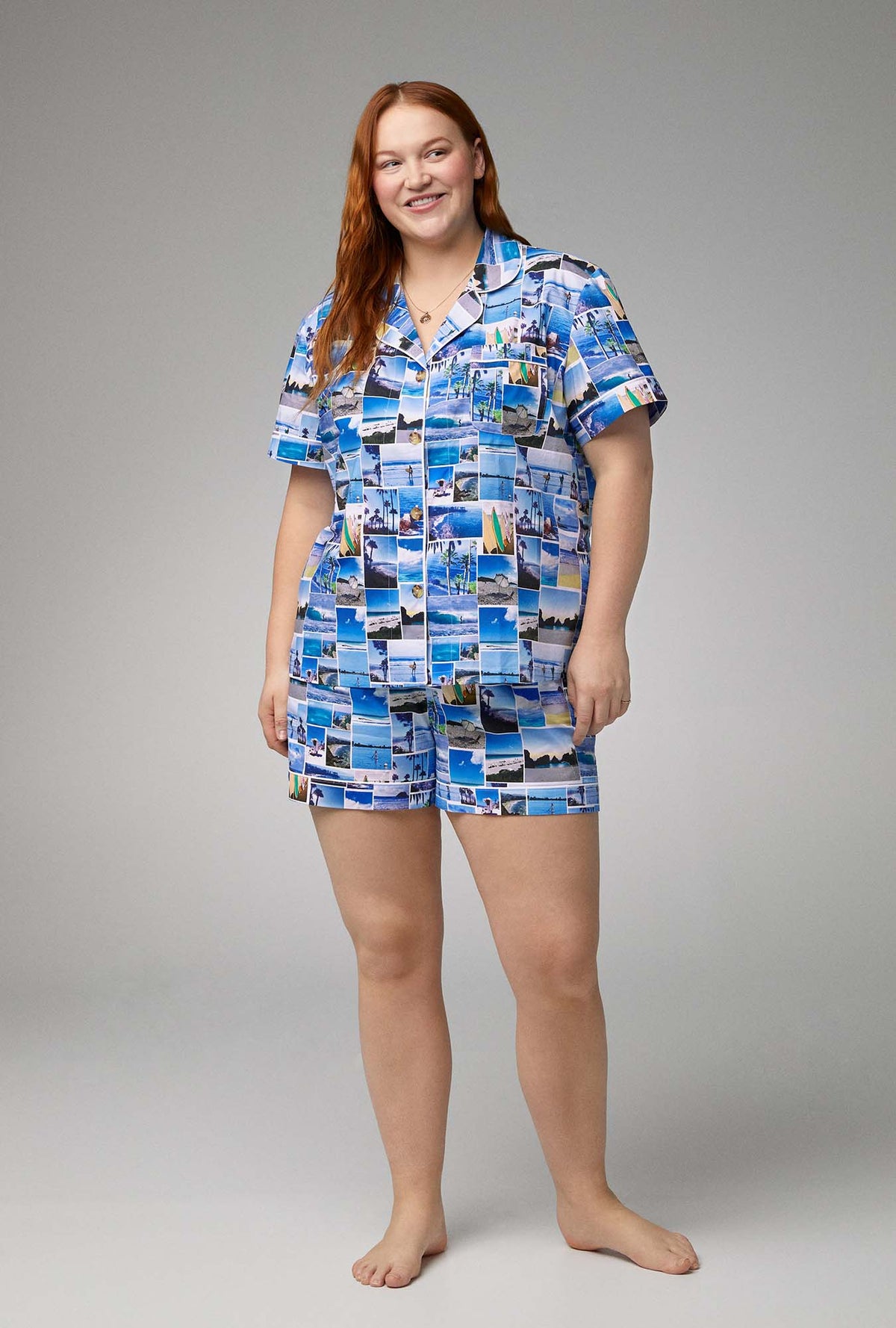 A lady wearing blue short sleeve classic shorty woven cotton poplin plus size pj set with beach day print.