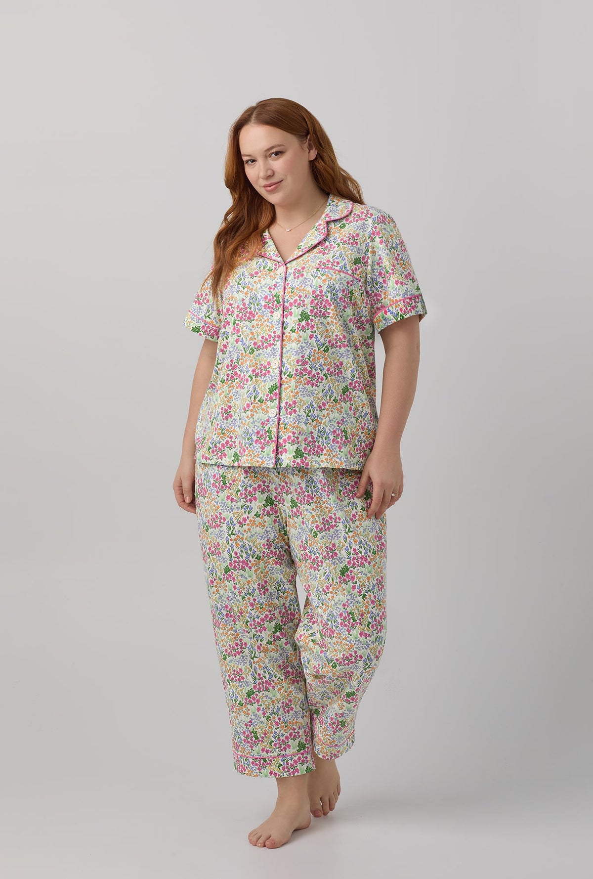A lady wearing multi color shoe=rt sleeve clasic stretch jersey cropped plus size pj set with cottage garden print.