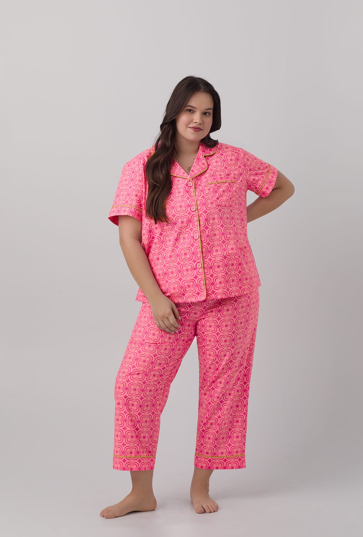 A lady wearing pink short sleeve cropped plus size pj set with  summer geo print.