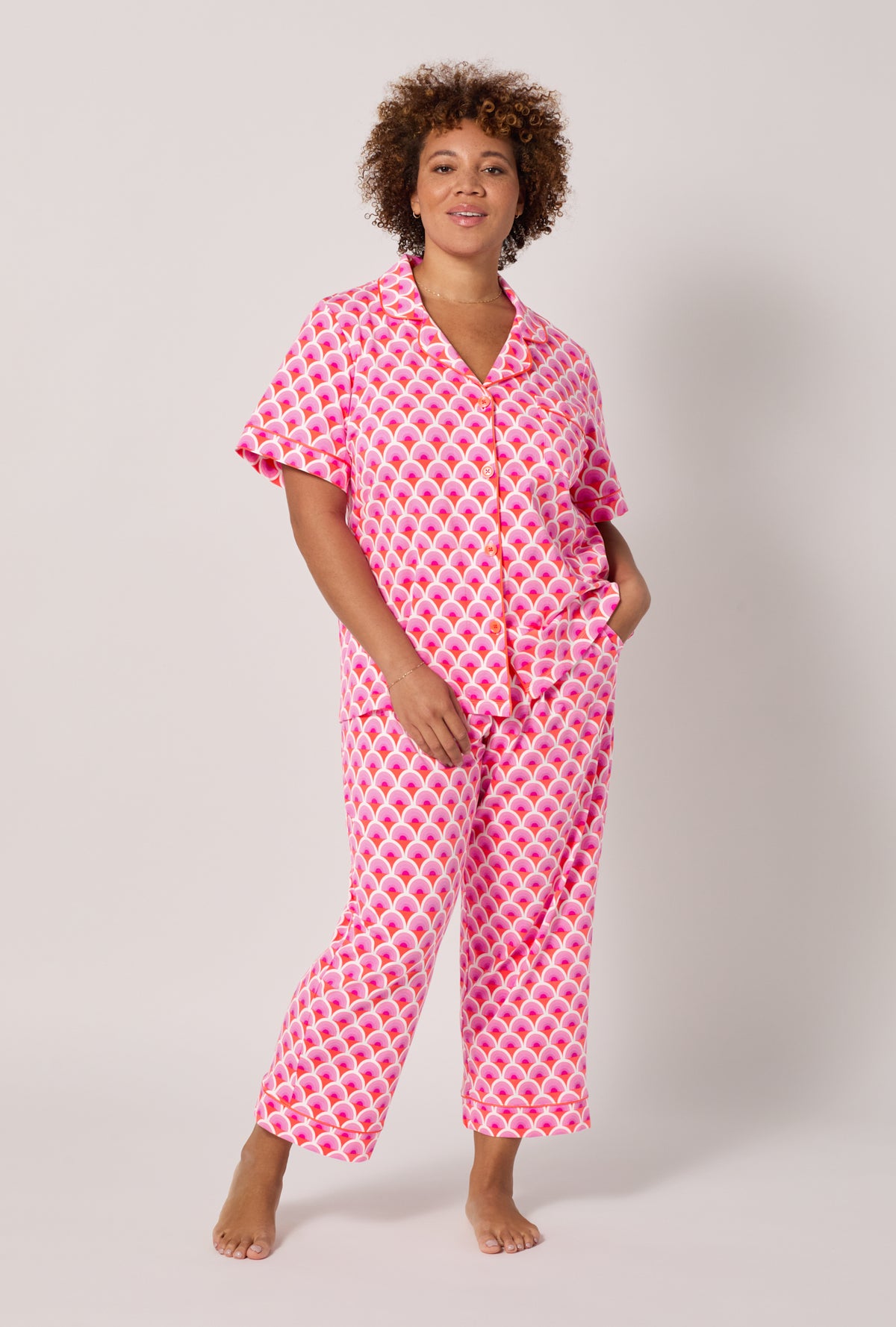 A lady wearing plus size BedHead x Trina Turk Scallop Short Sleeve Classic Stretch Jersey Cropped Pj Set