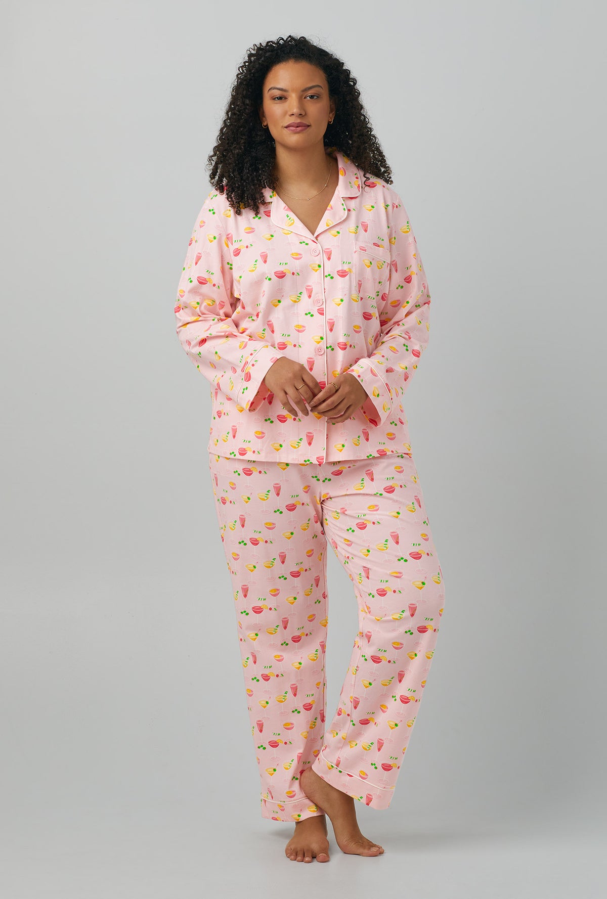 A lady wearing plus size pink Long Sleeve Classic Stretch Jersey PJ Set with Pink Mixology print