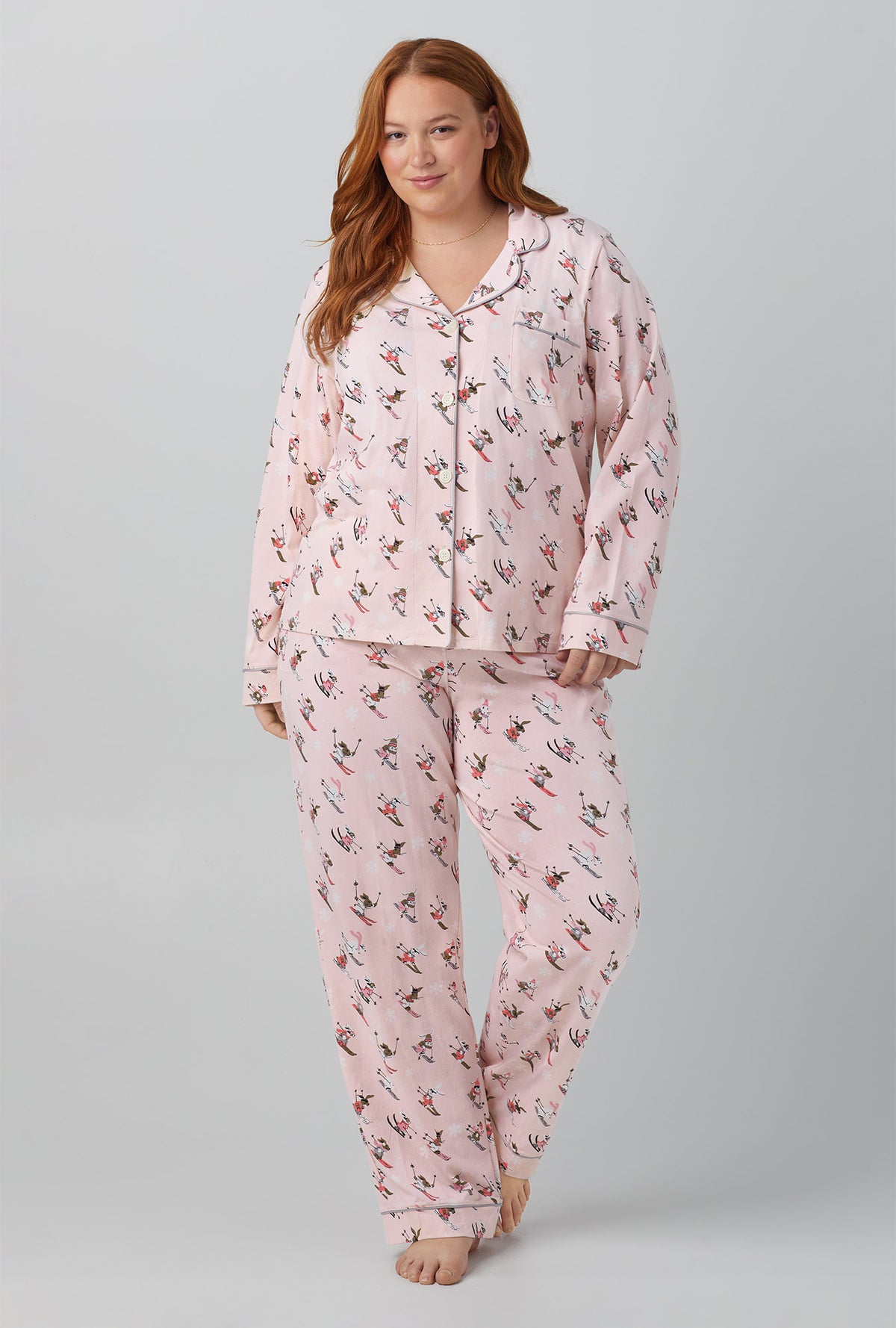 A lady wearing pink long sleeve classic stretch jersey plus pj set with ski bunnies print.