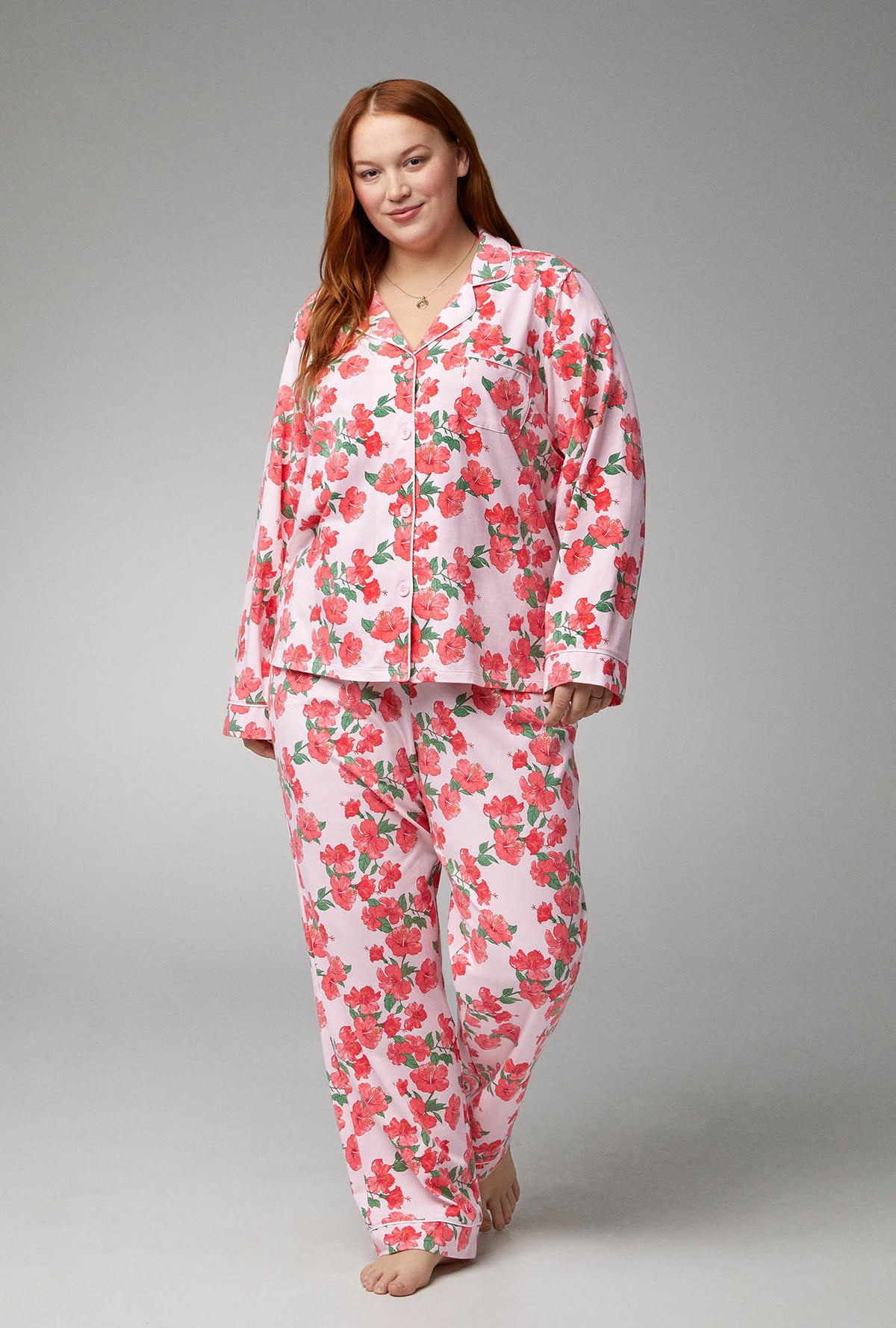 A lady wearing pink long sleeve classic stretch jersey plus size pj set with sweer hibisus.