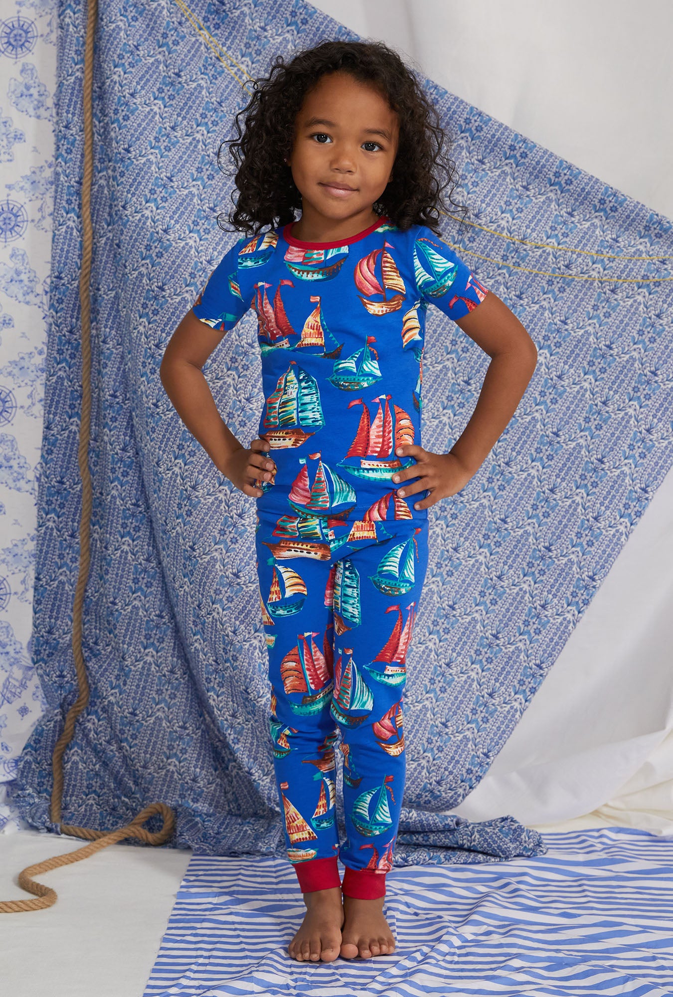 A girl wearing blue short sleeve pj set with come sail away print