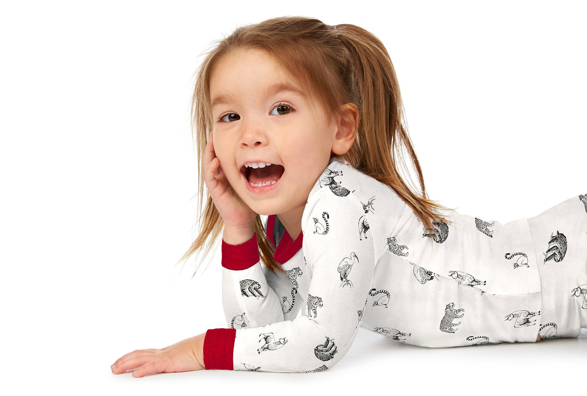 A baby wearing white long sleeve pj set with animal print