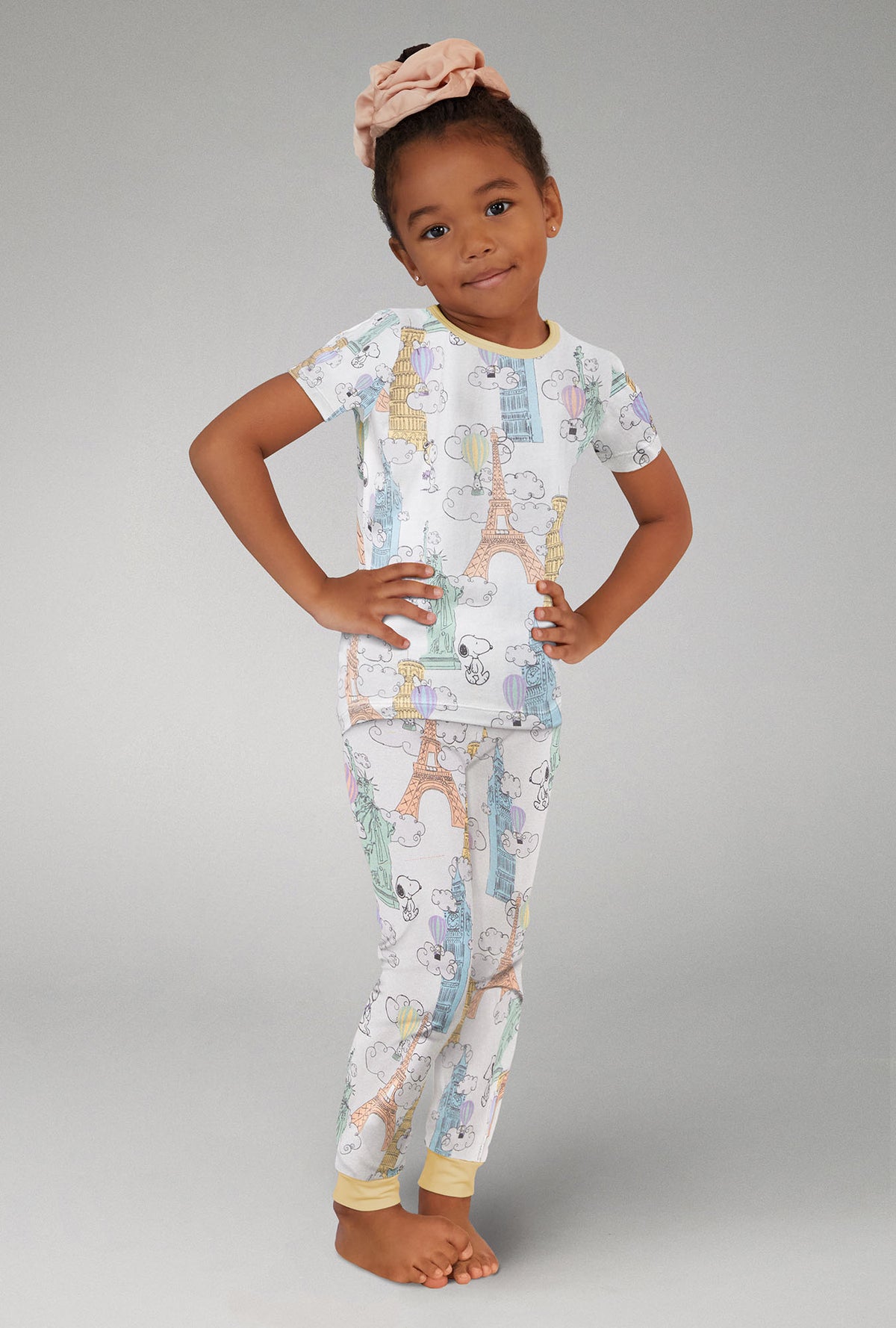 A girl wearing pink Short Sleeve Stretch Jersey Kids PJ Set with Bon Voyage Snoopy  print