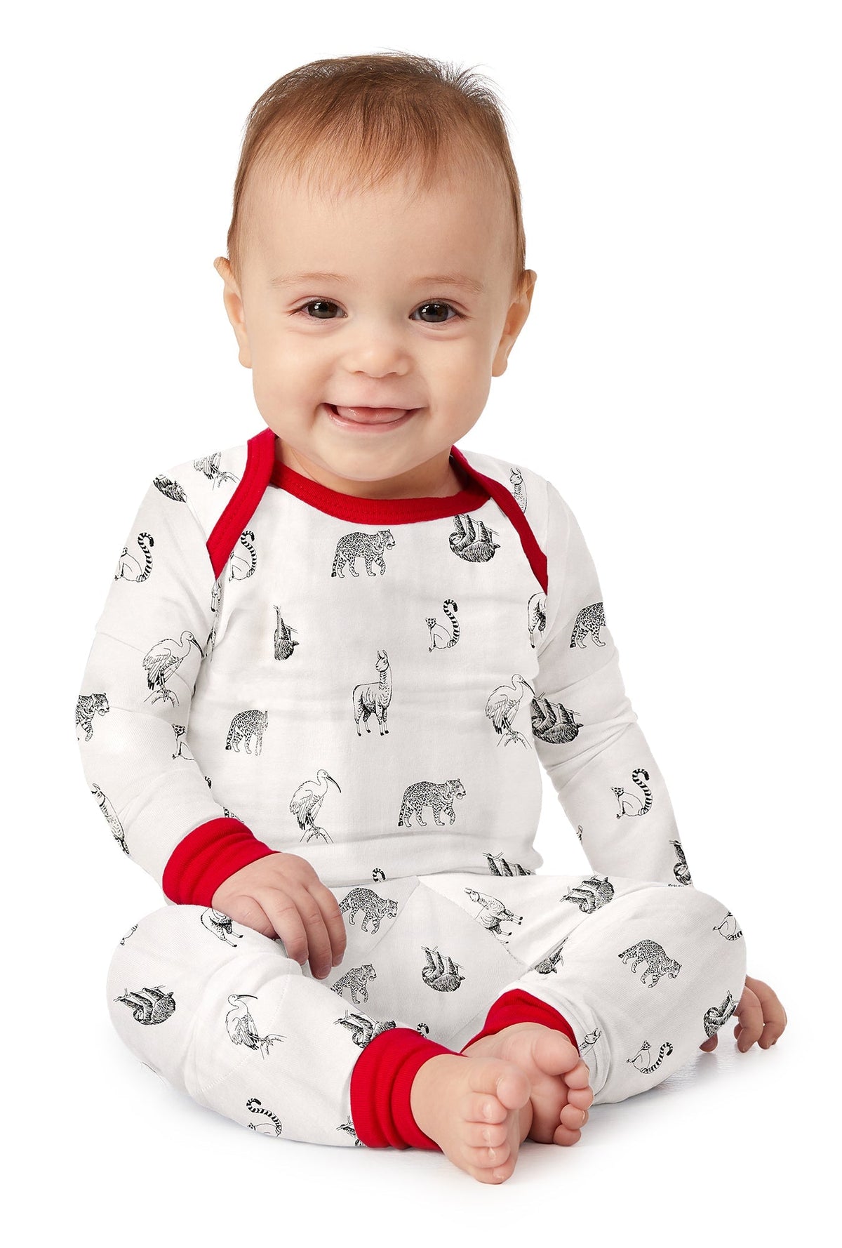 A baby wearing white long sleeve pj set with animal print