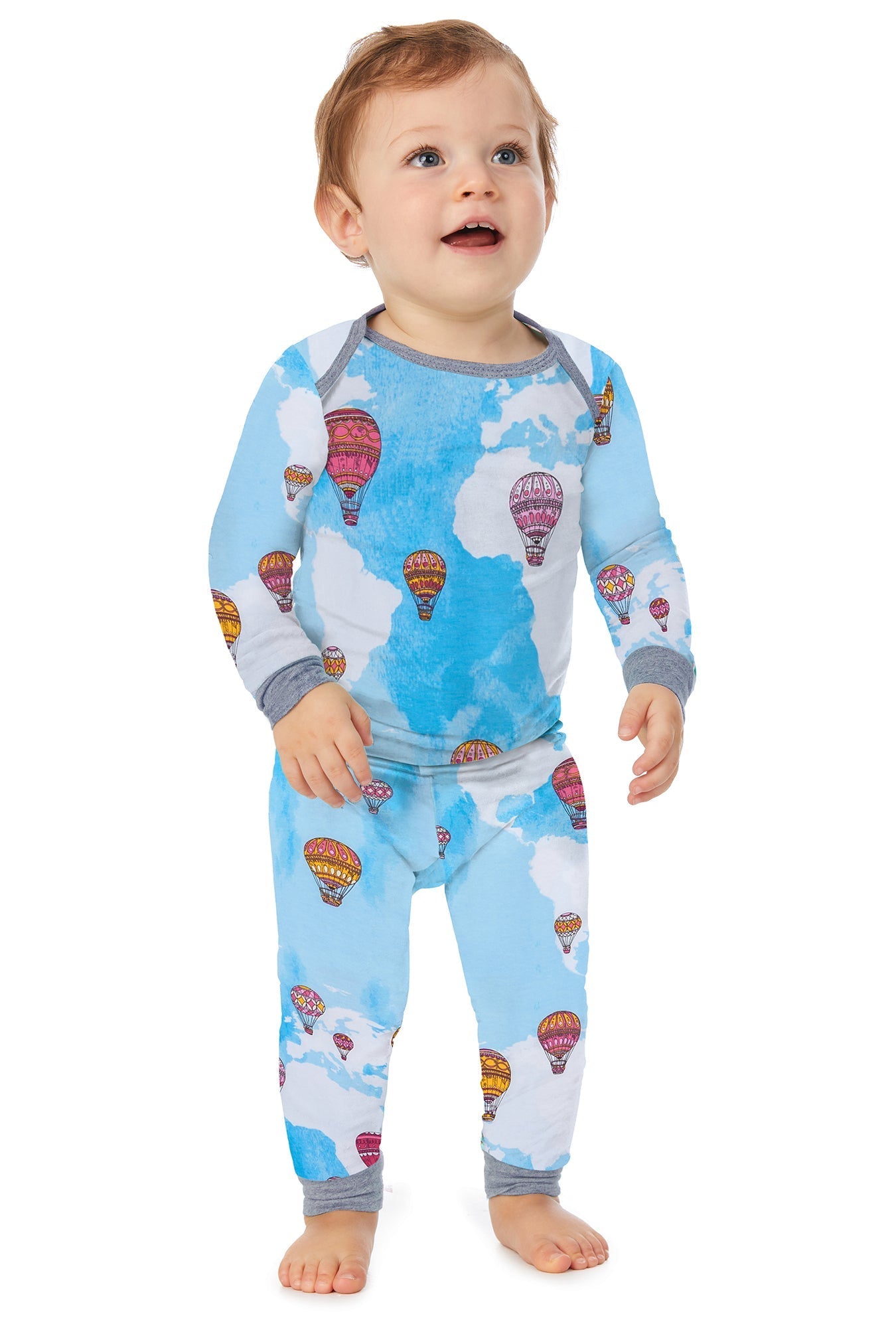 A baby wearing a long sleeve pj set with parachute in the sky pattern.