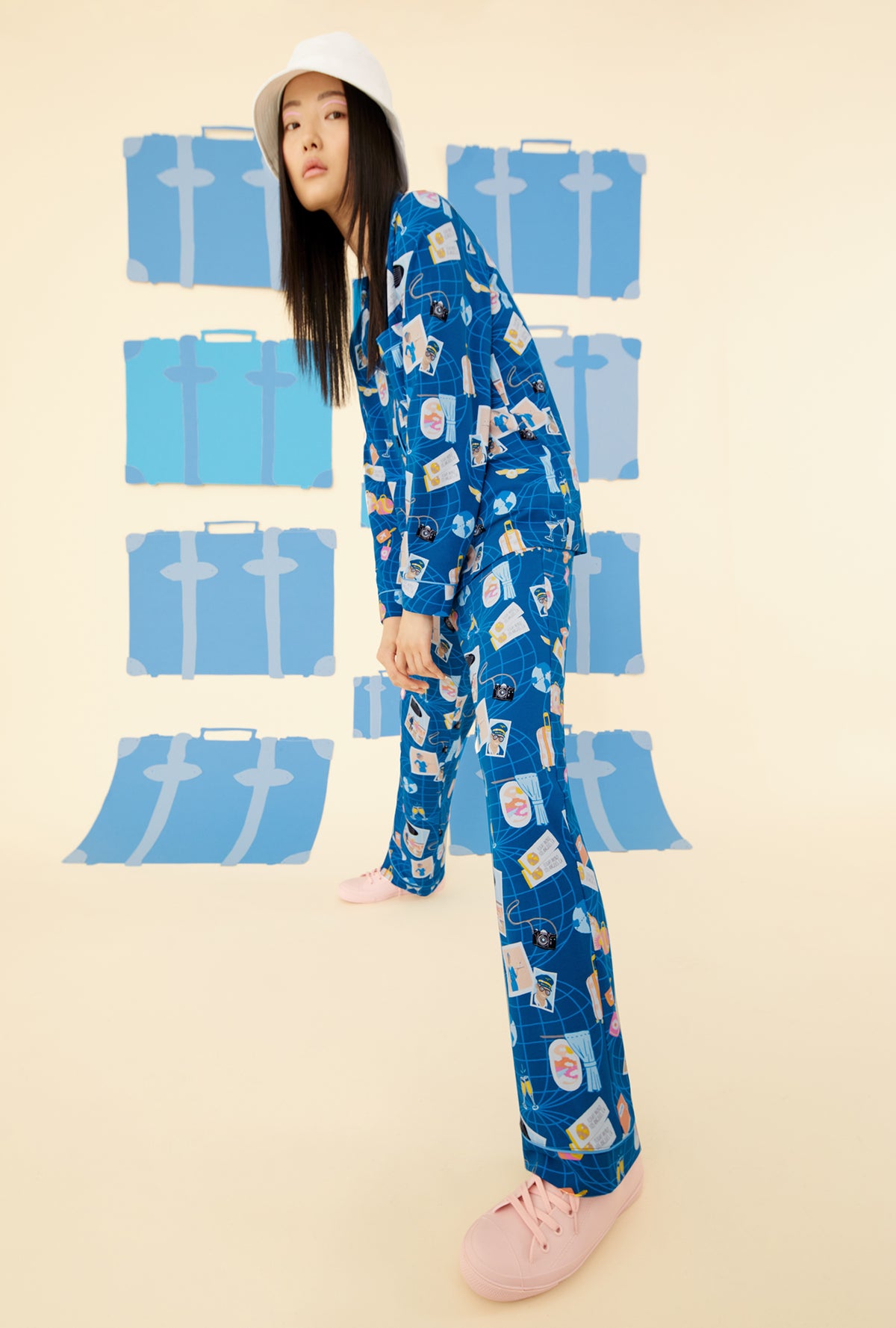 A lady wearing a blue long sleeve pajama set with jet setter pattern.
