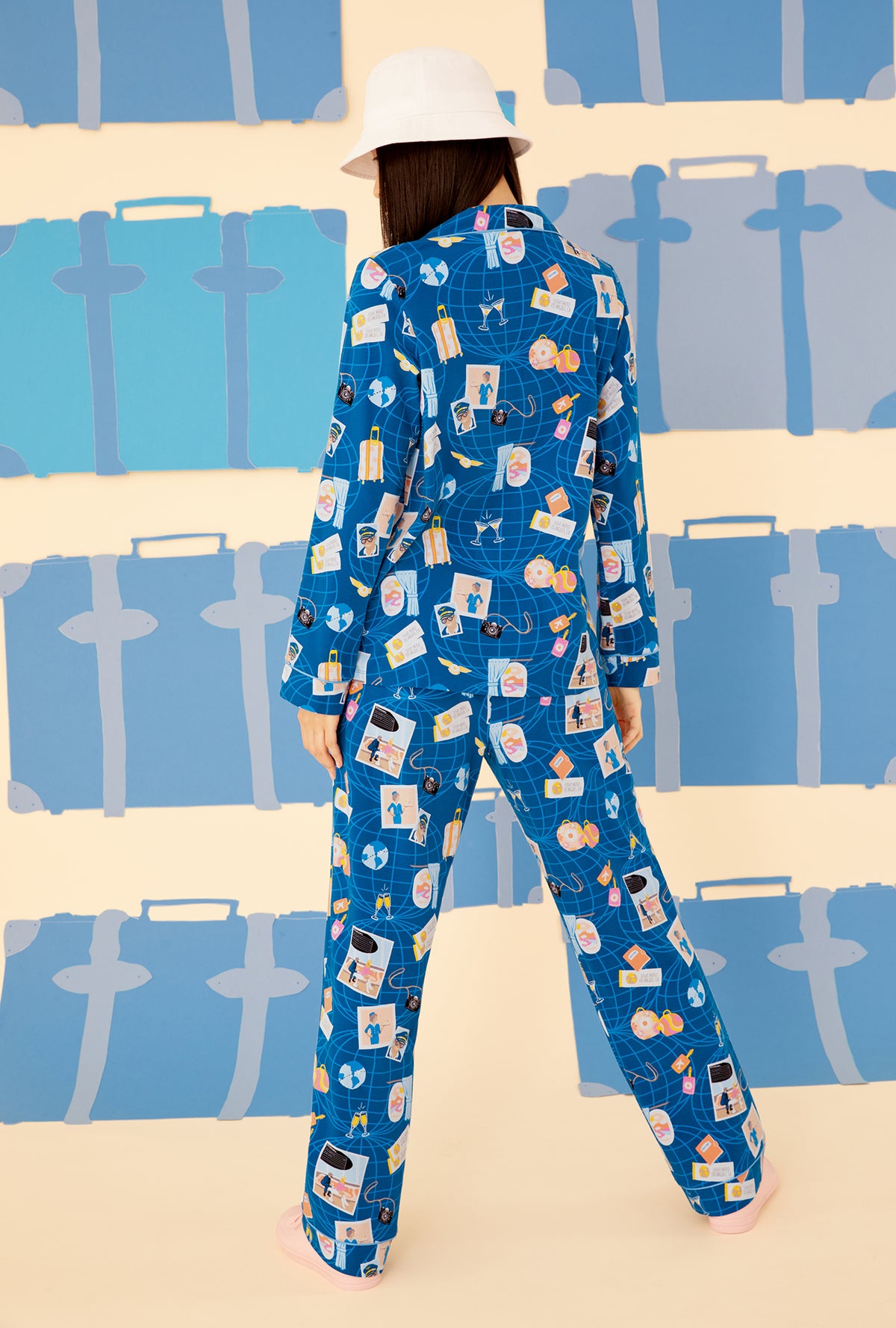 A lady wearing a blue long sleeve pajama set with jet setter pattern.