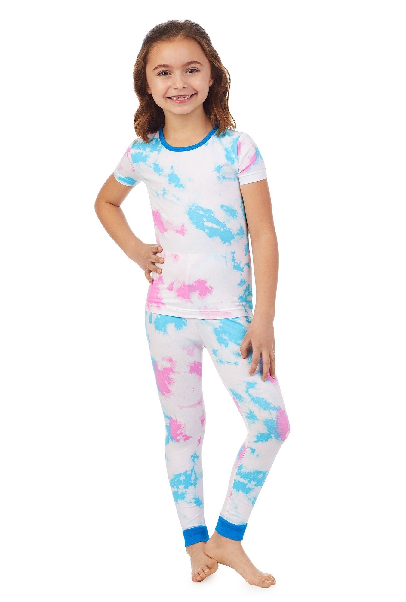 A kid wearing a white short sleeve pj set with multicolor tiedye pattern.