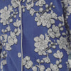 A lady wearing a blue long sleeve plus size pj set with white blossom pattern.