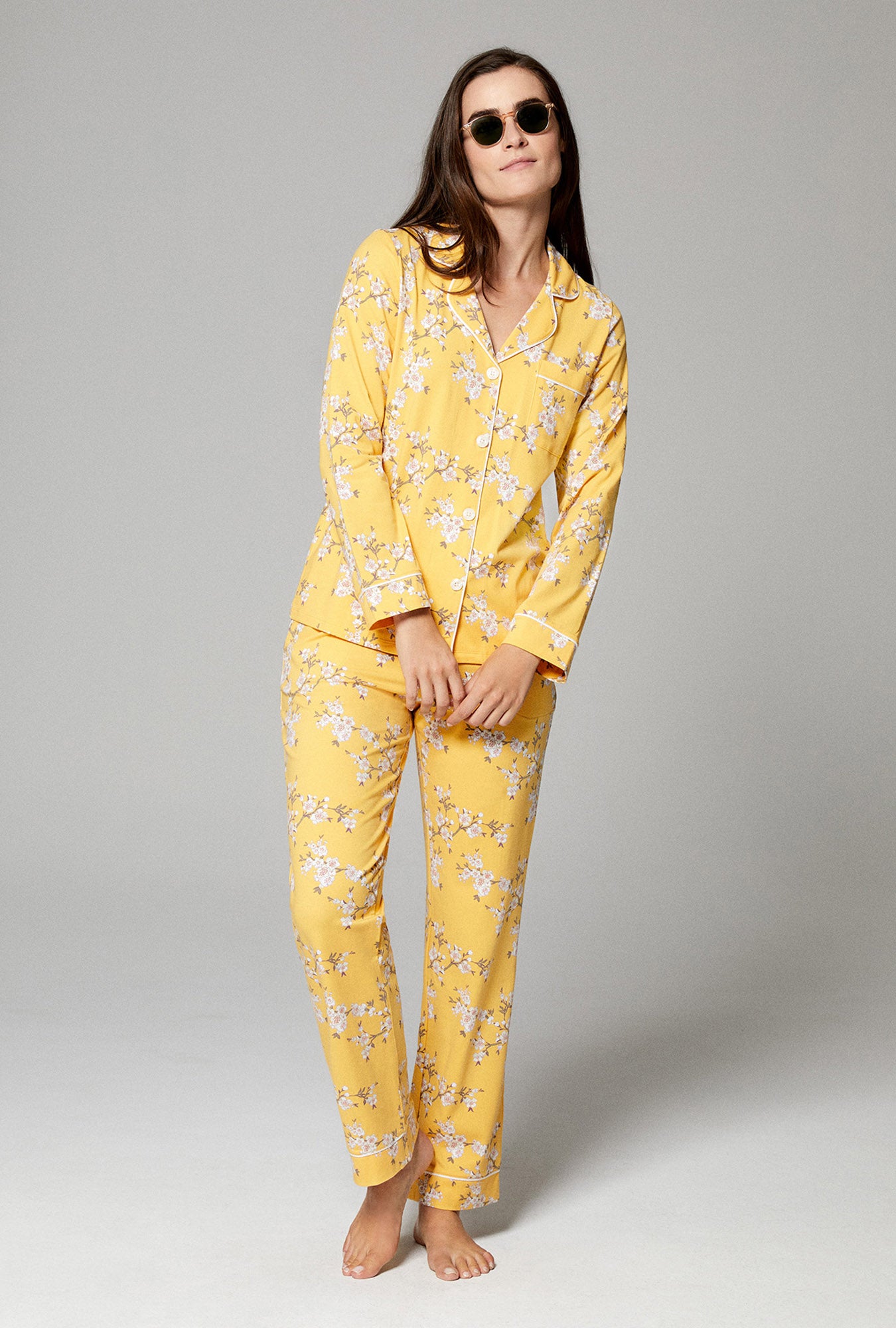 A lady wearing gold color long sleeve classic pj set with a floral print