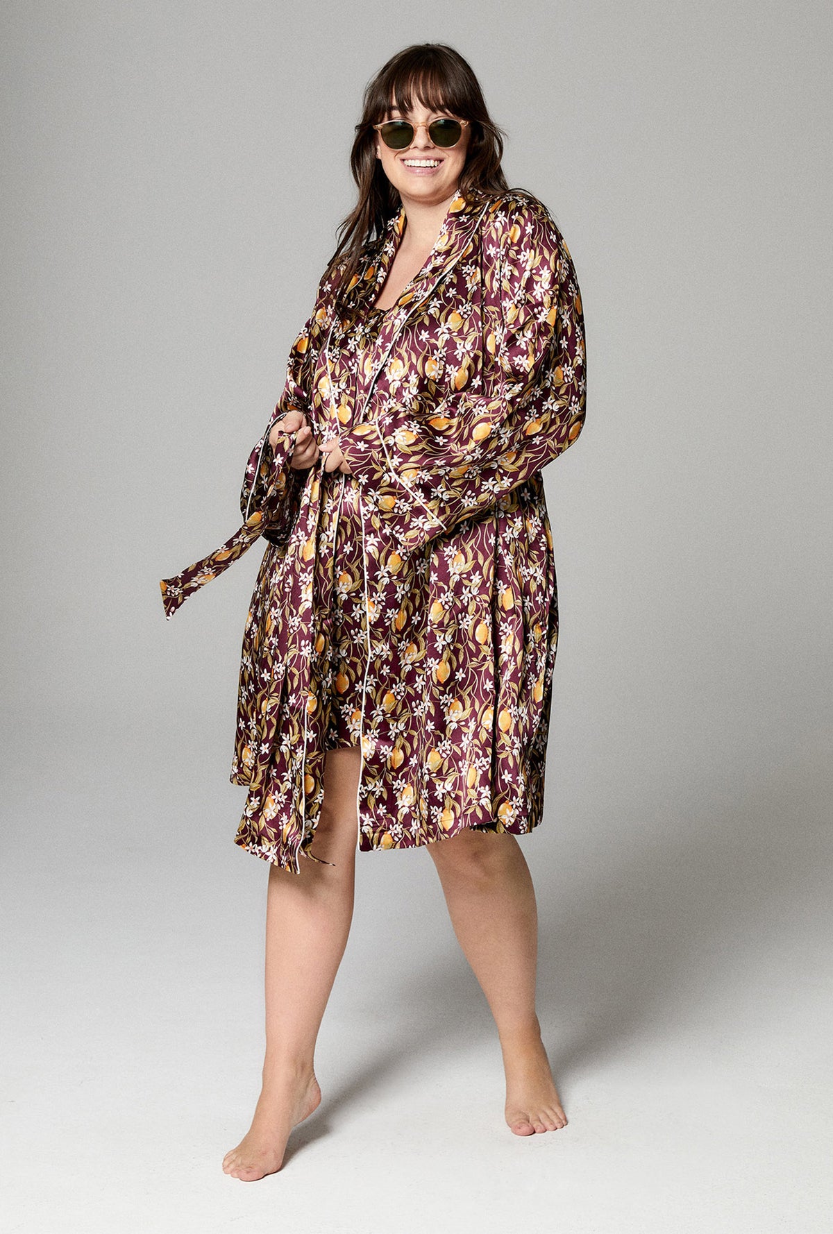 A lady wearing burgundy shawl collar robe with floral print