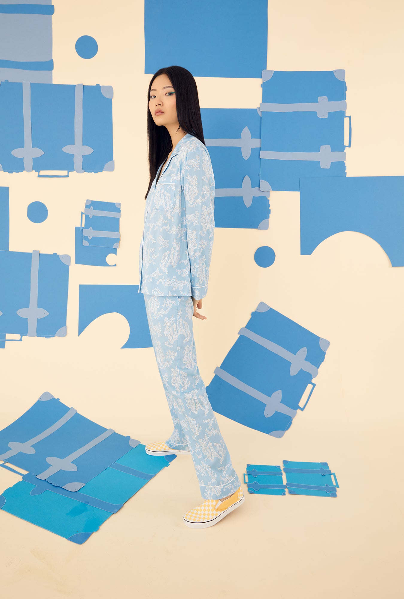  A lady wearing a blue long sleeve pajama set with white eifel pattern.