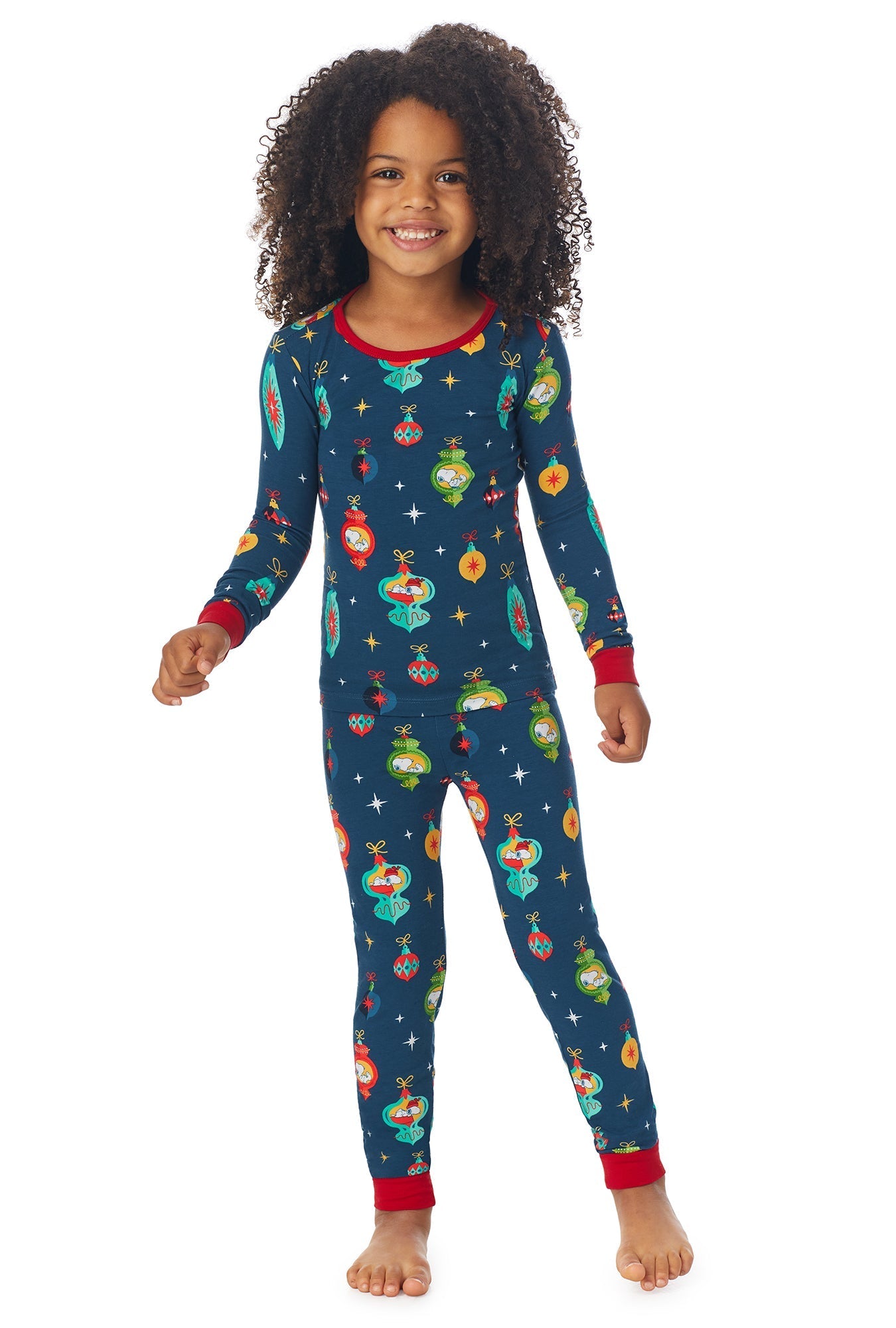 A girl wearing a blue long sleeve pj set with snoopy ornaments pattern.