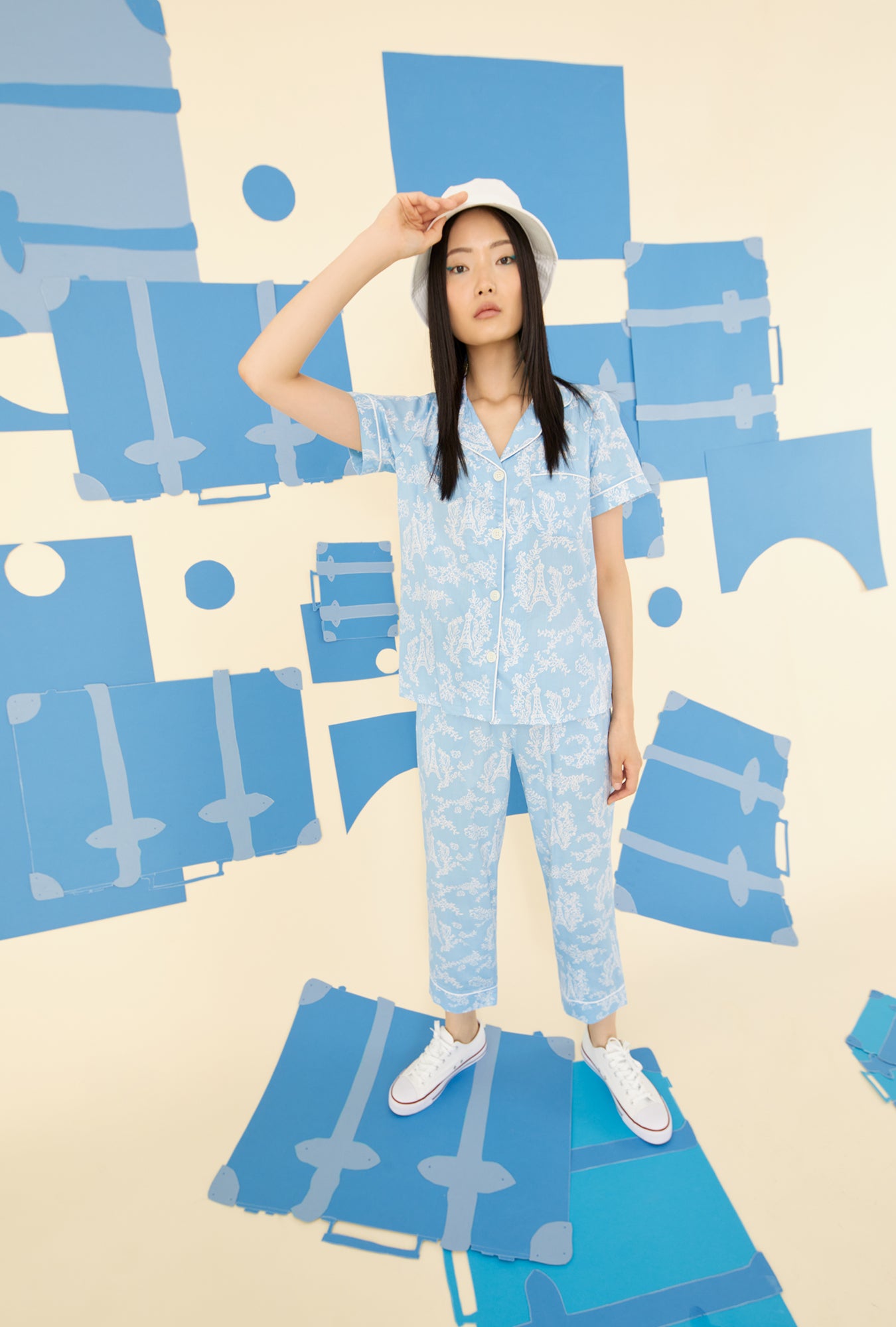 A lady wearing a blue short sleeve pajama set with white eifel pattern.