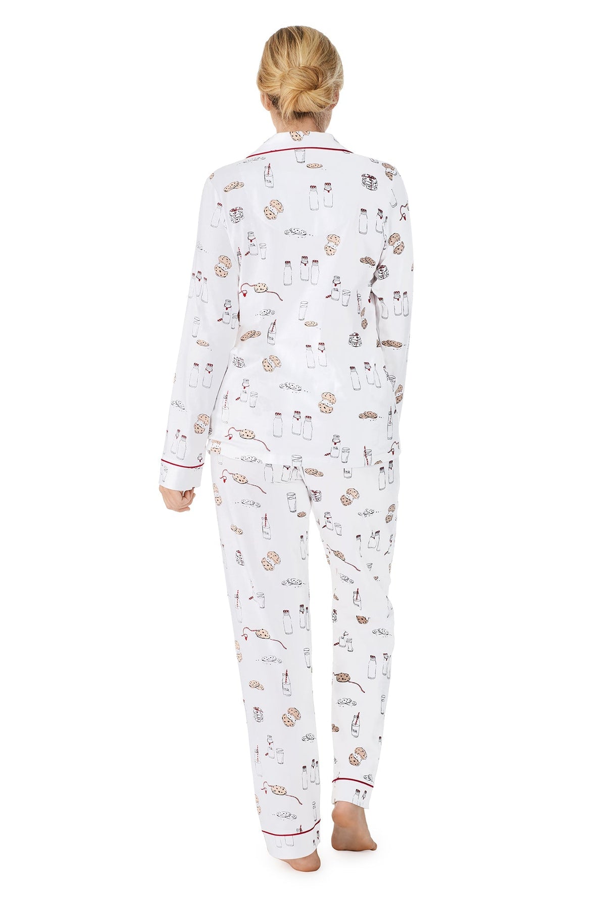 A lady wearing a white long sleeve pj set with milk and cookies pattern. 