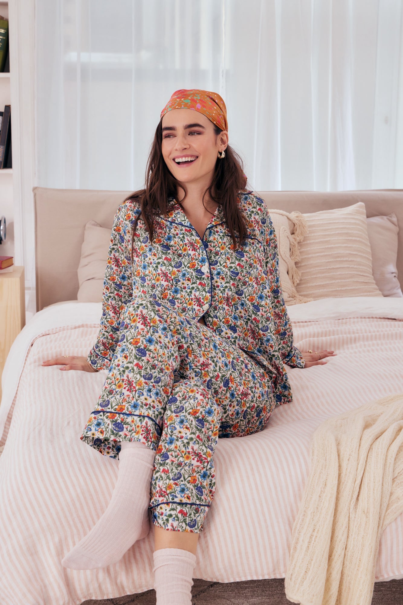 A lady wearing a long sleeve pj set with multicolor floral pattern.