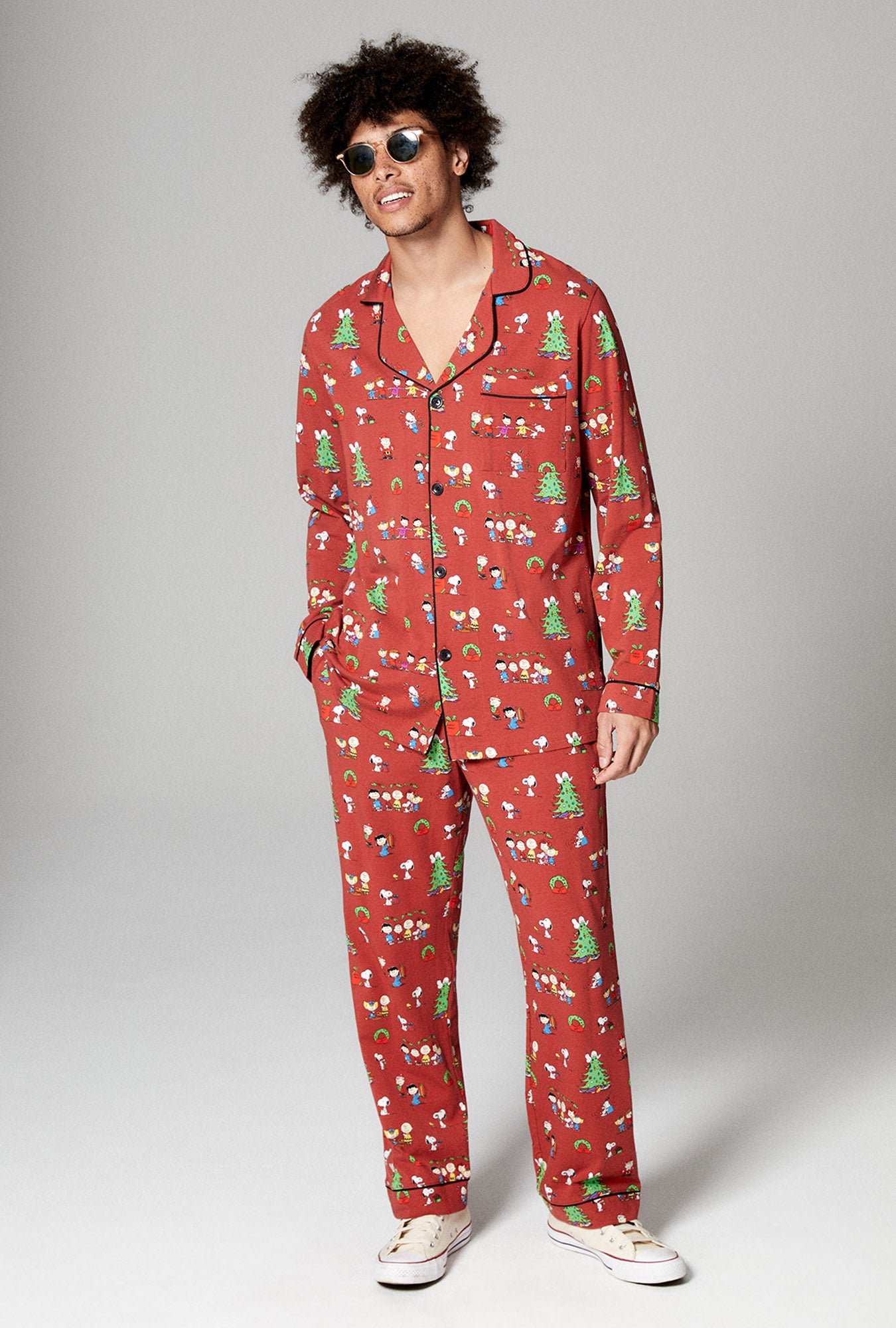 A man wearing brown long sleeve classic stretch jersey pj set with bedhead x peanuts holiday party print.
