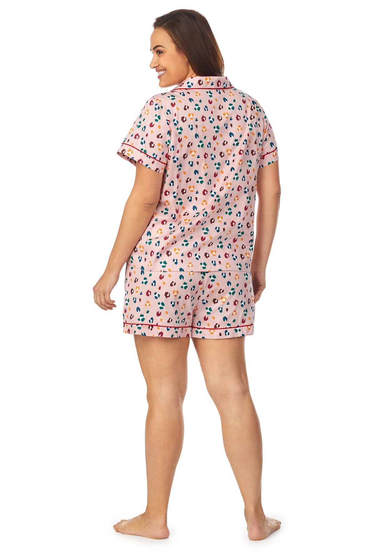 A lady wearing a short sleeve plus size pj set with multicolor pattern. 