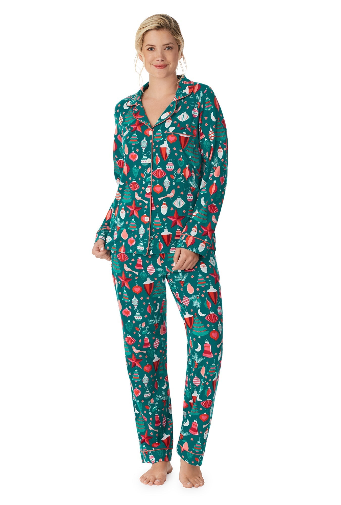 A lady wearing a green long sleeve pj set with seasonal decor pattern.